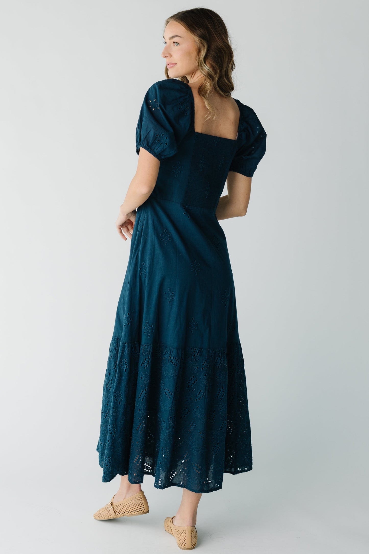 Back view of navy eyelet dress with square back neckline and short puff sleeves