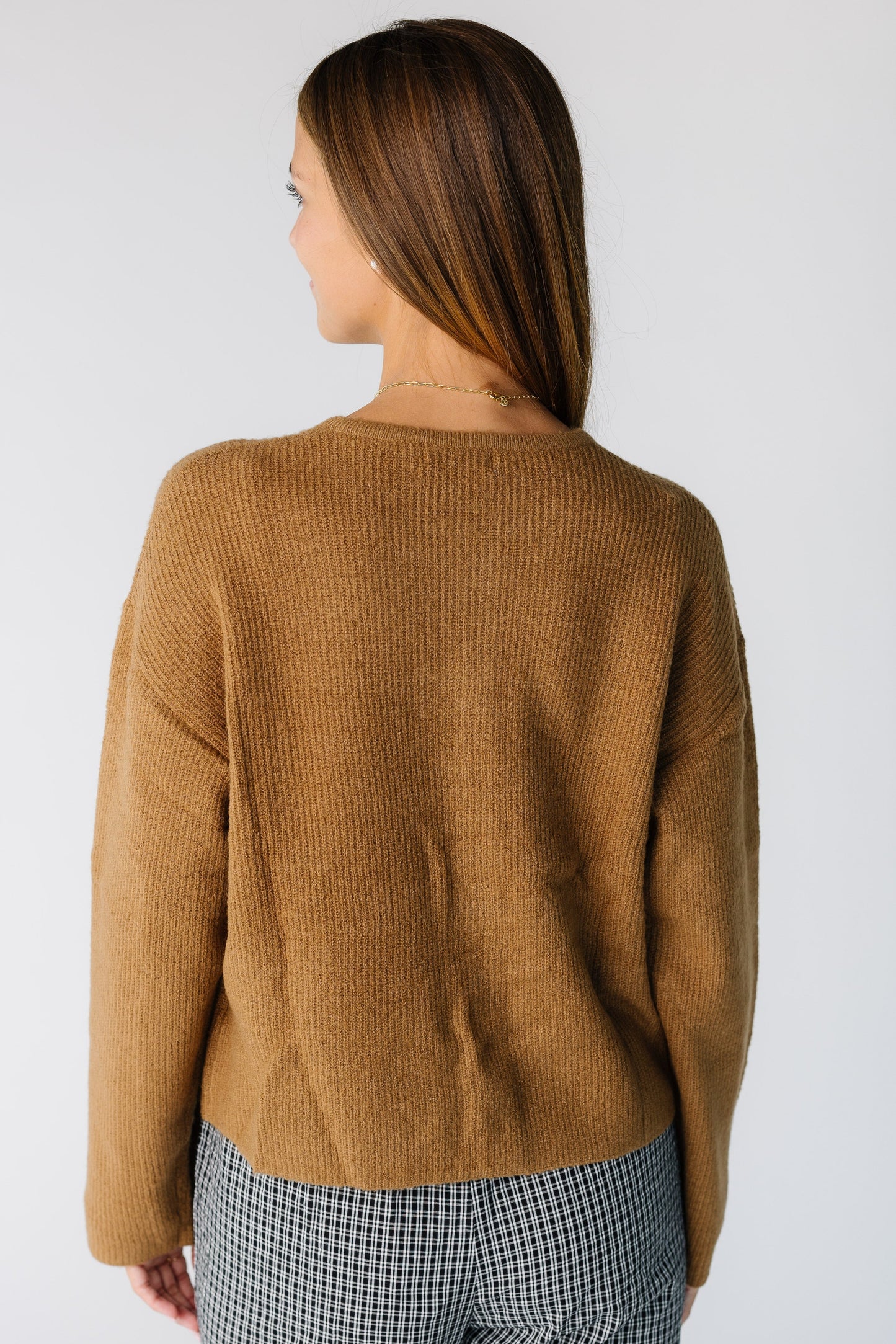 Back view of a woman wearing a brown long sleeve cardigan