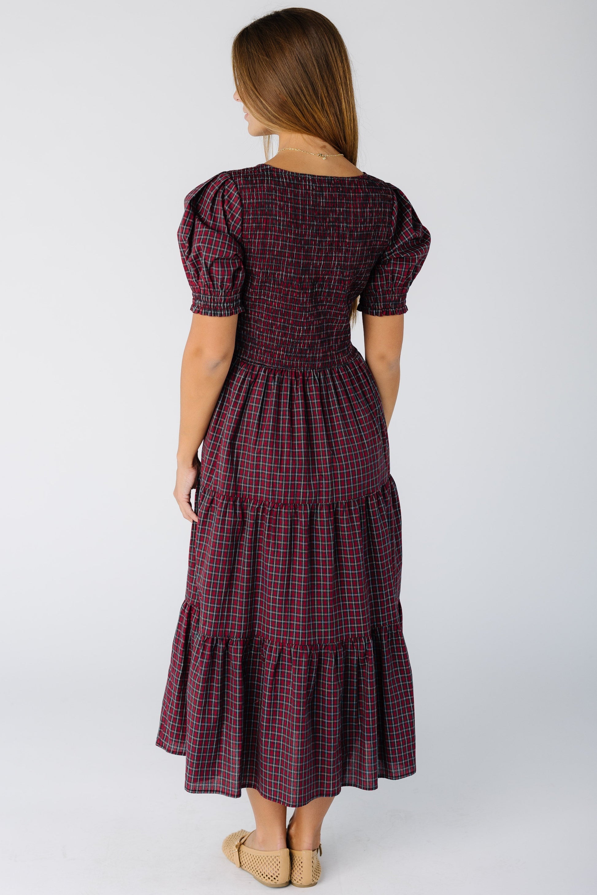 Back view of a woman wearing a modest red plaid midi dress with short sleeves