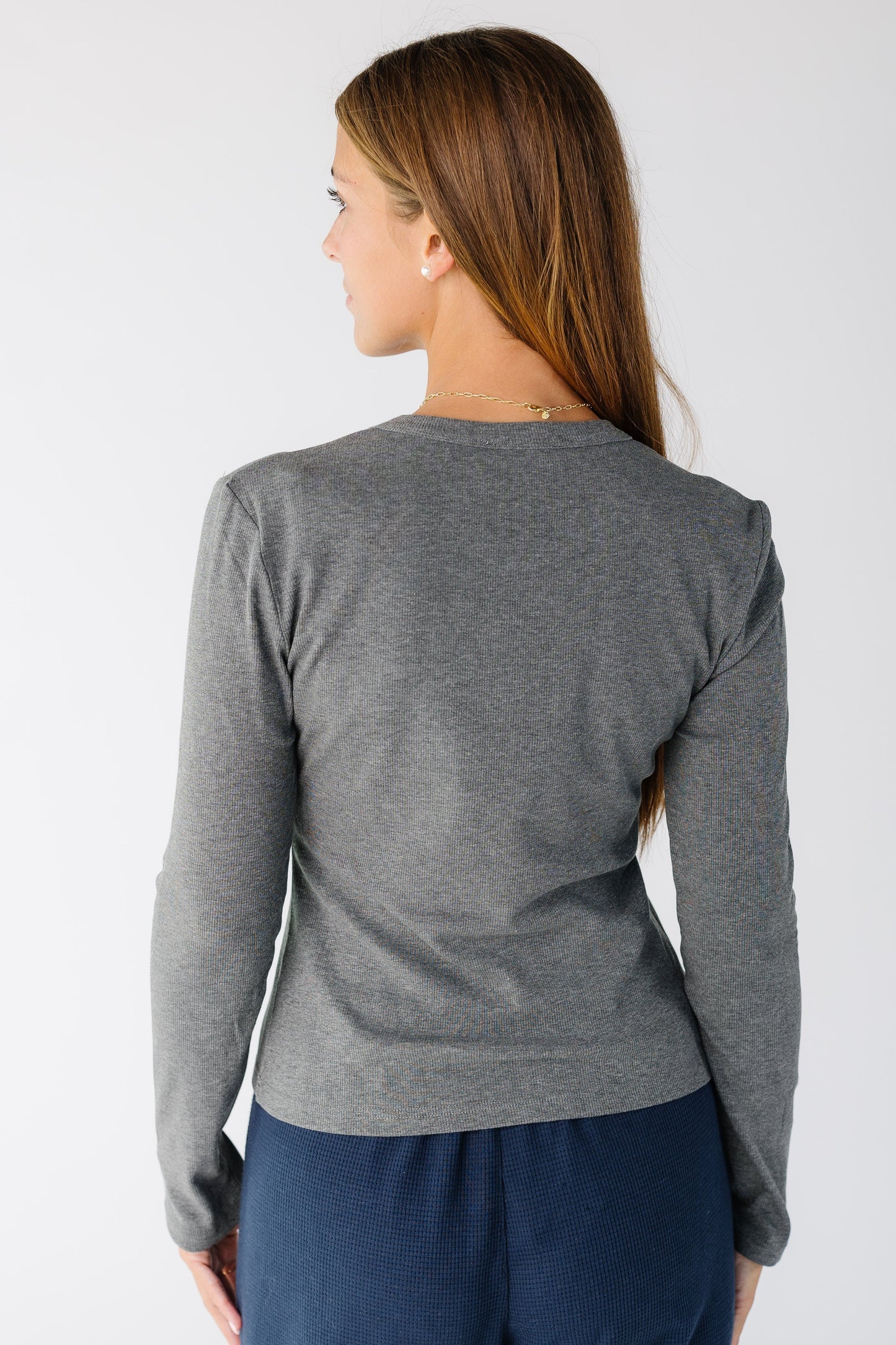 Back view of a woman wearing a grey top with long sleeves