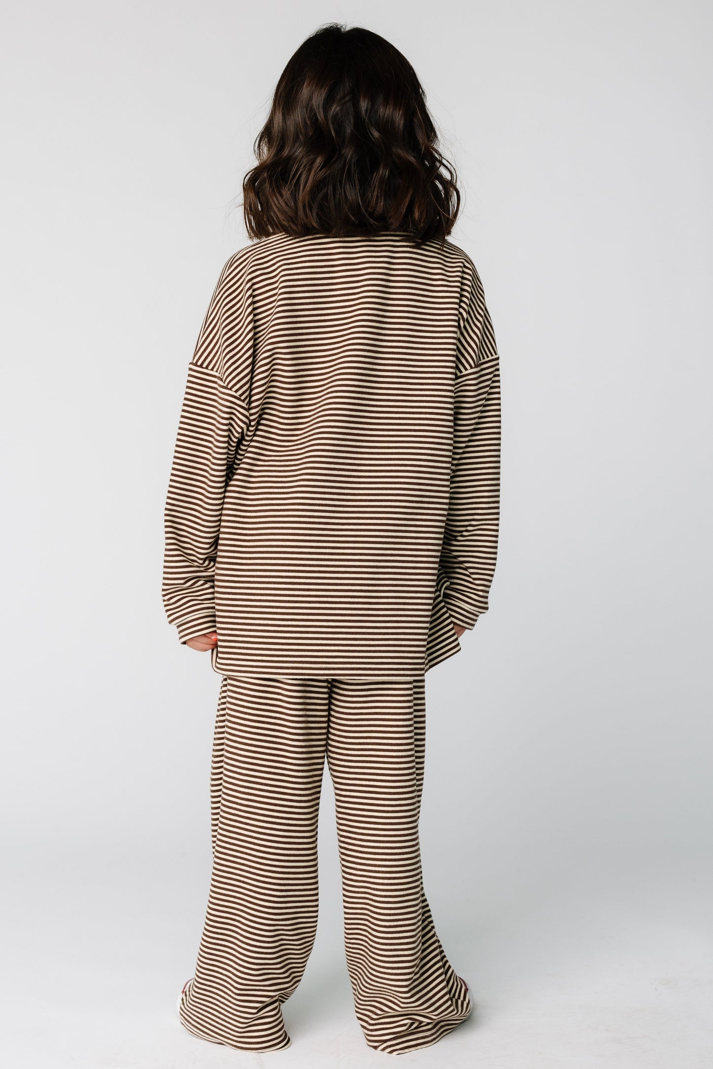 Back view of a girl wearing a brown stripe lounge set