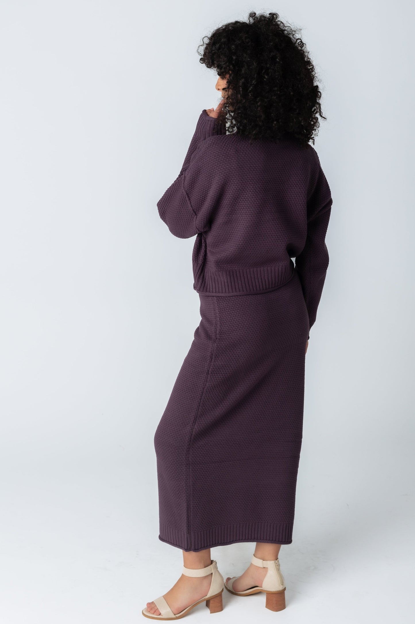 Back view of plum textured long sleeve sweater and midi skirt set