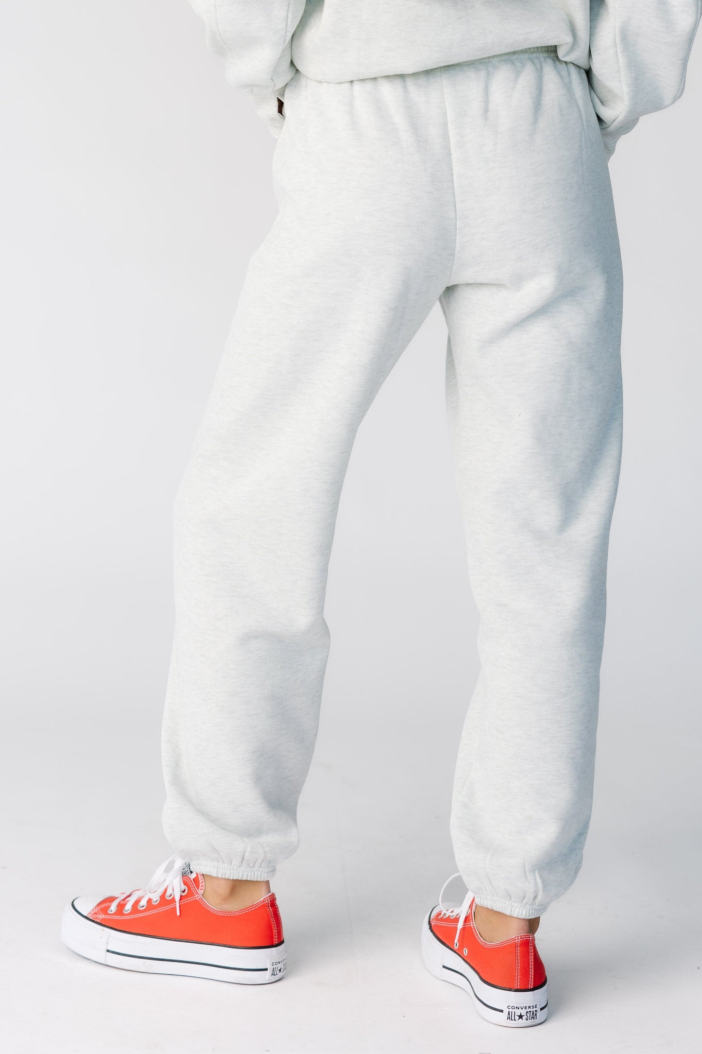 Back view of a woman wearing a pair of heather grey sweatpants