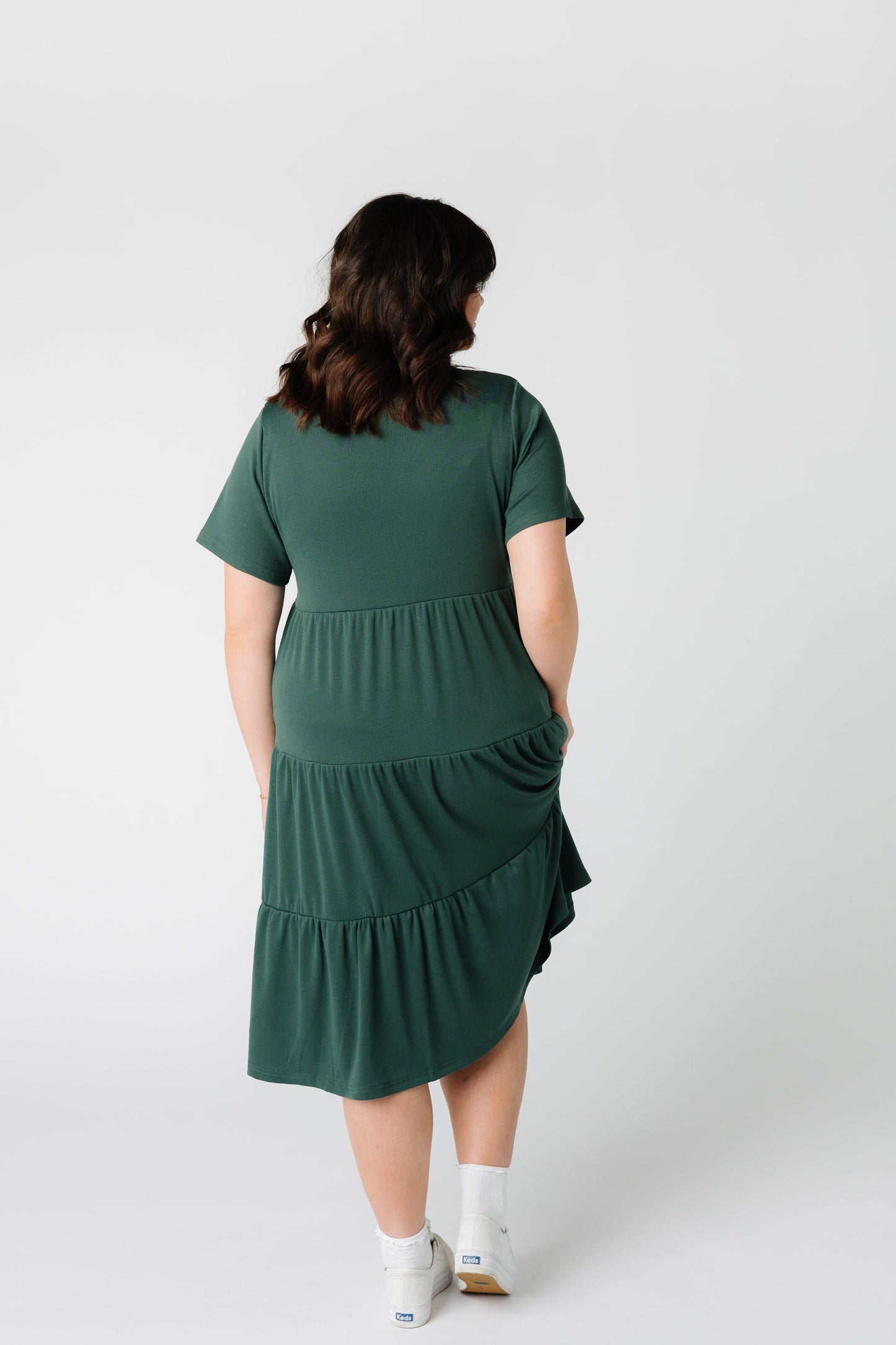 Back view of a woman wearing a green tiered dress