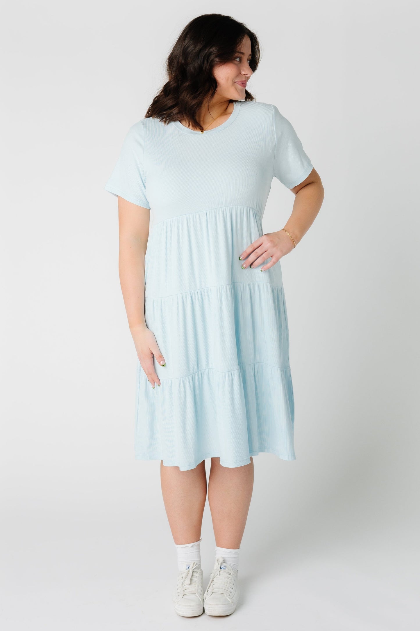 A woman wearing a light blue plus size tiered dress