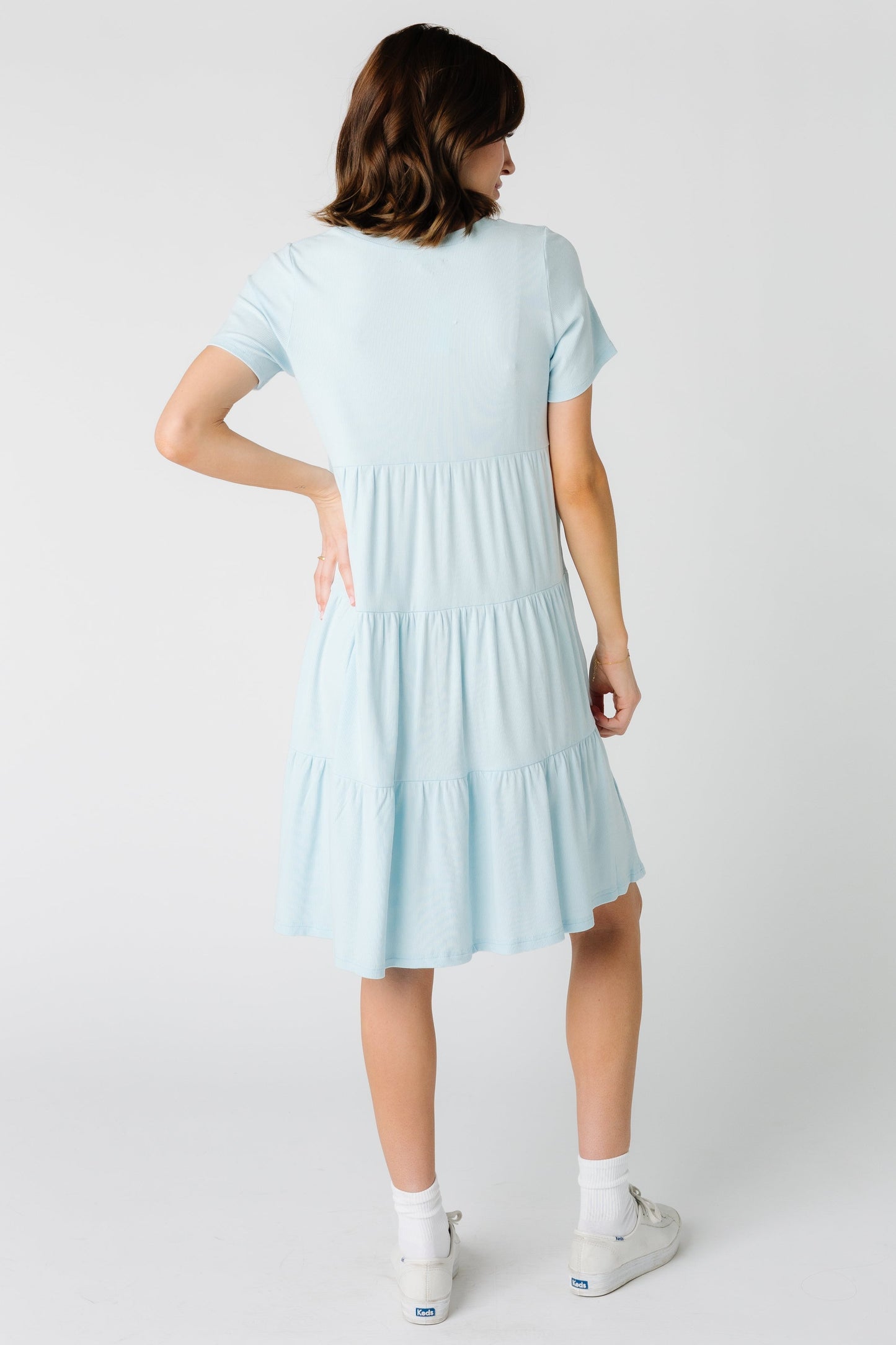 Back view of a woman wearing a light blue tiered dress
