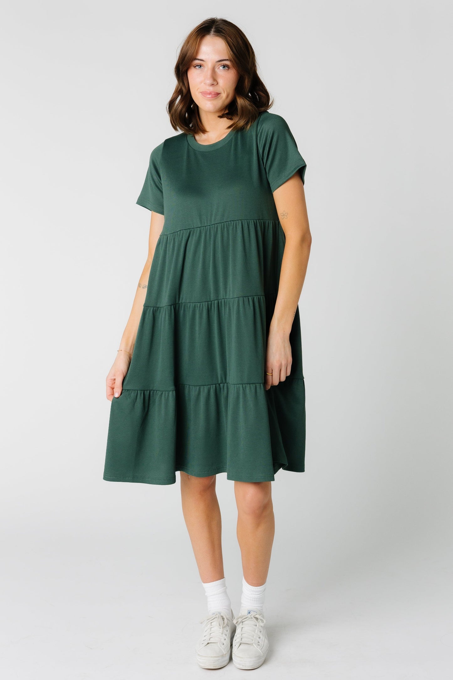 A woman wearing a green tiered knee length dress