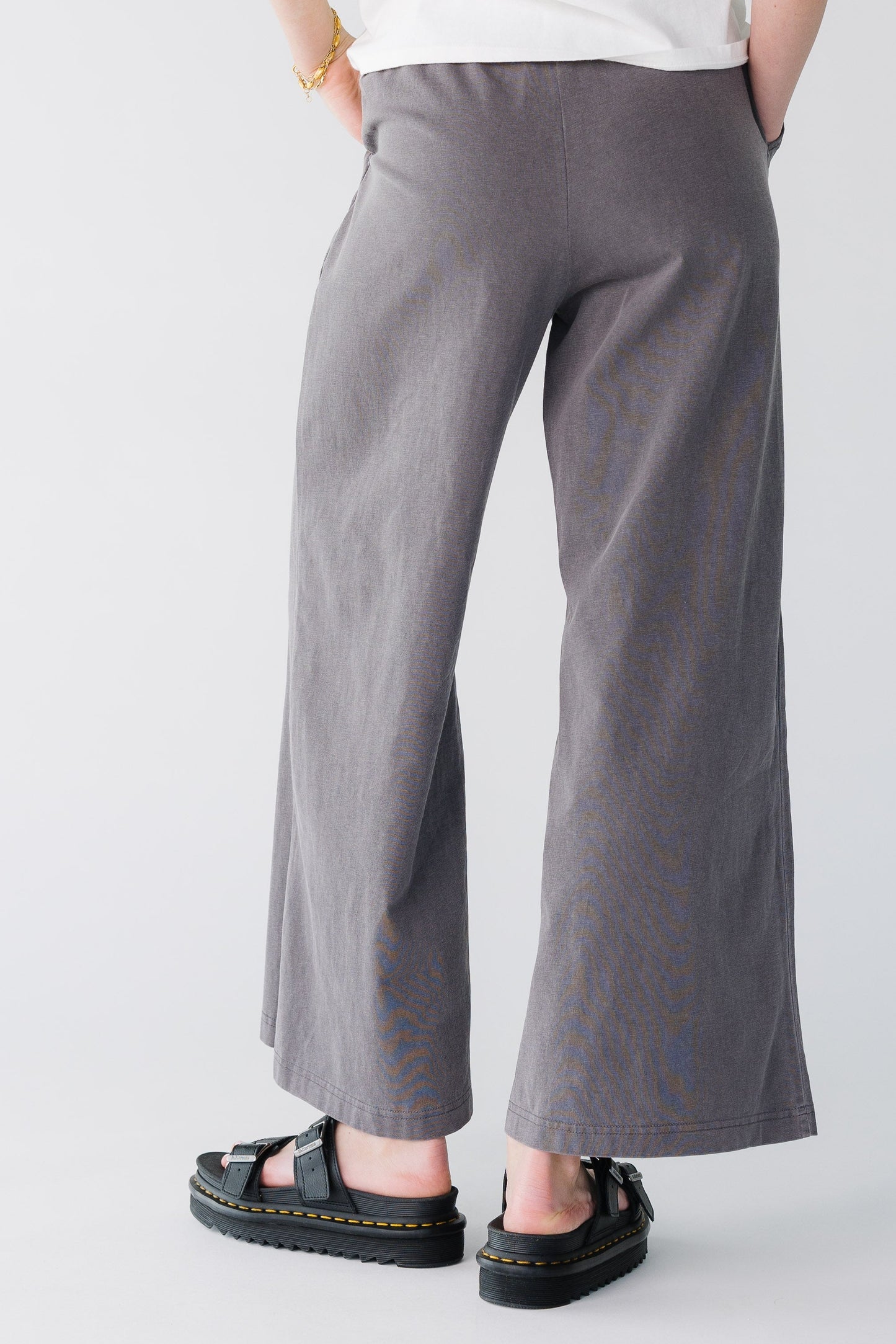 Back view of a woman wearing charcoal wide leg pants.