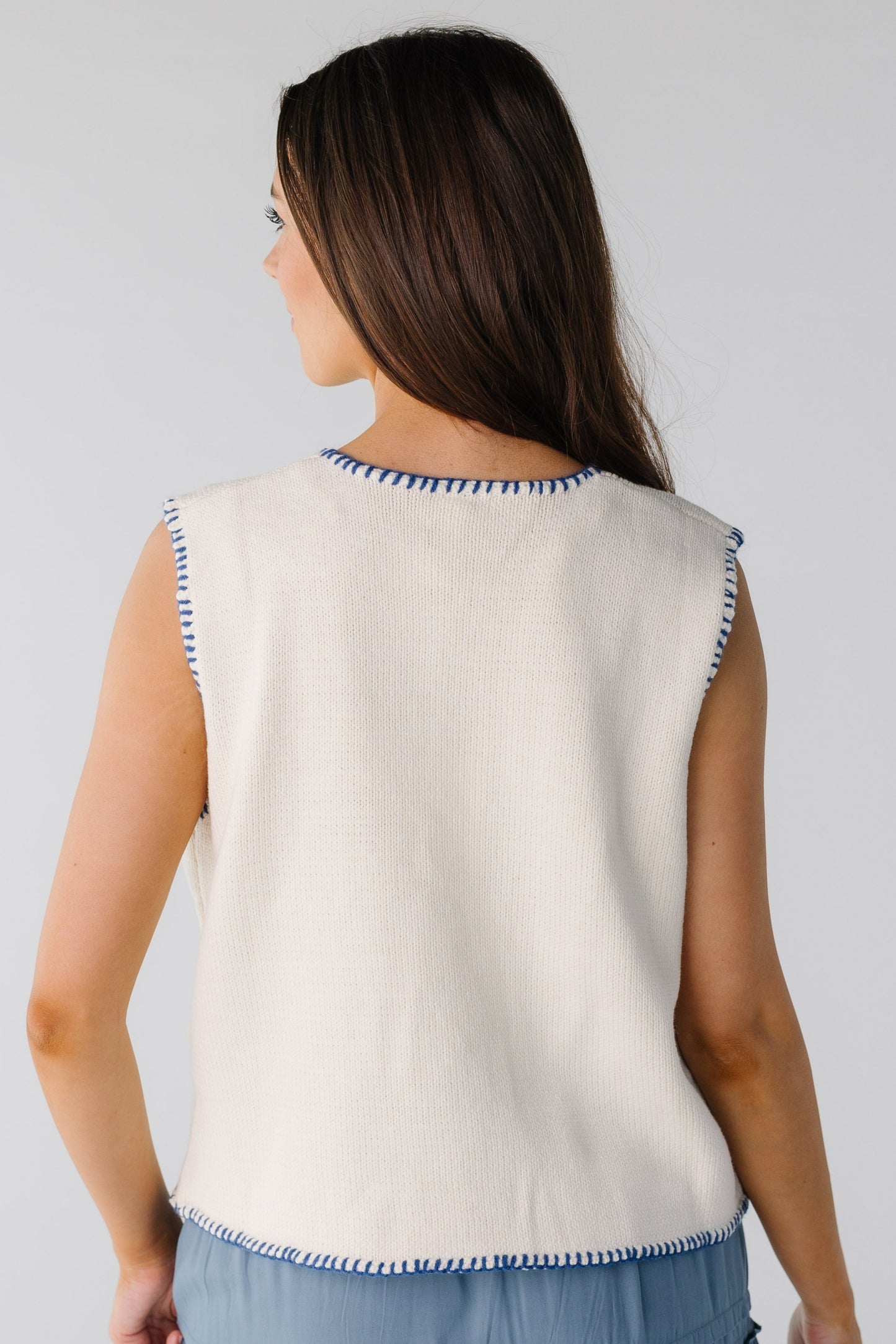 Back view of white sweater vest with navy stitching
