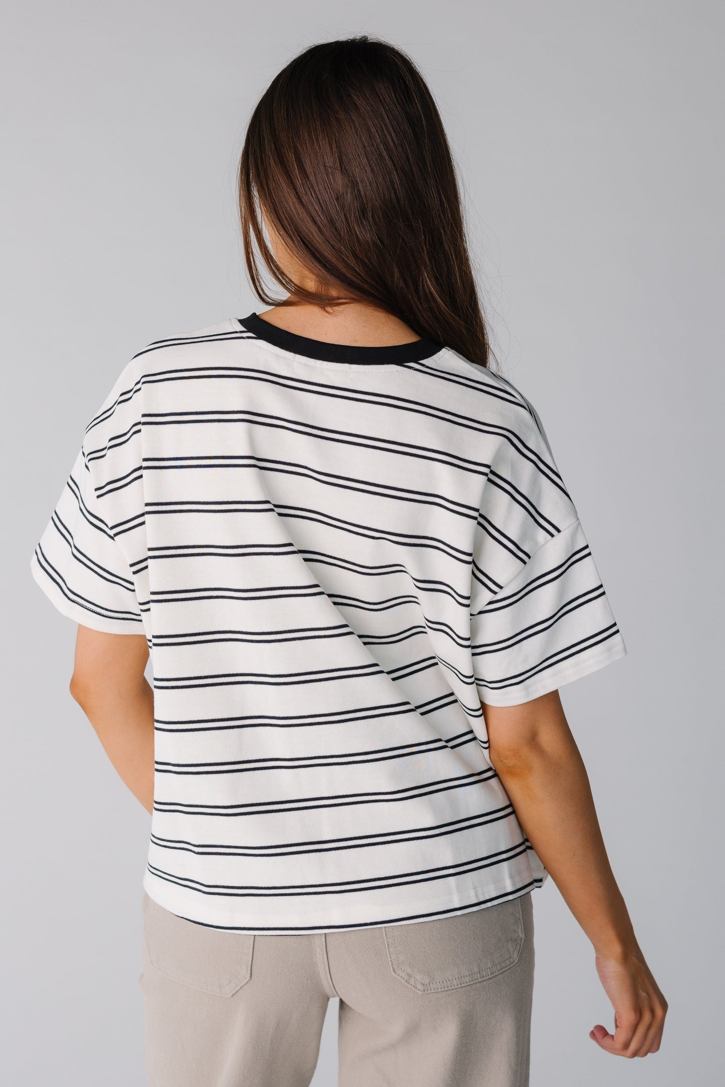Back view of white and black stripe boxy tee