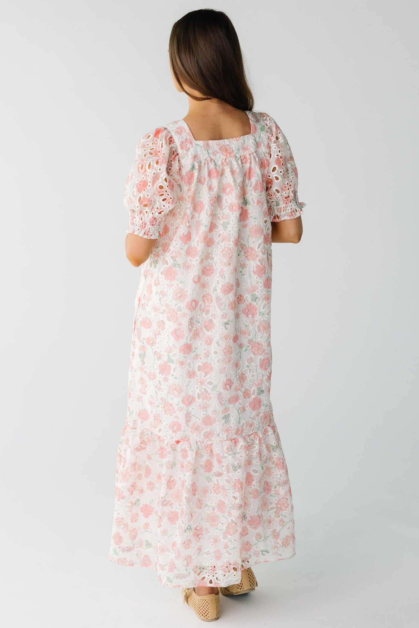 Back view of eyelet midi in pink floral with short puff sleeves and wide bottom ruffle