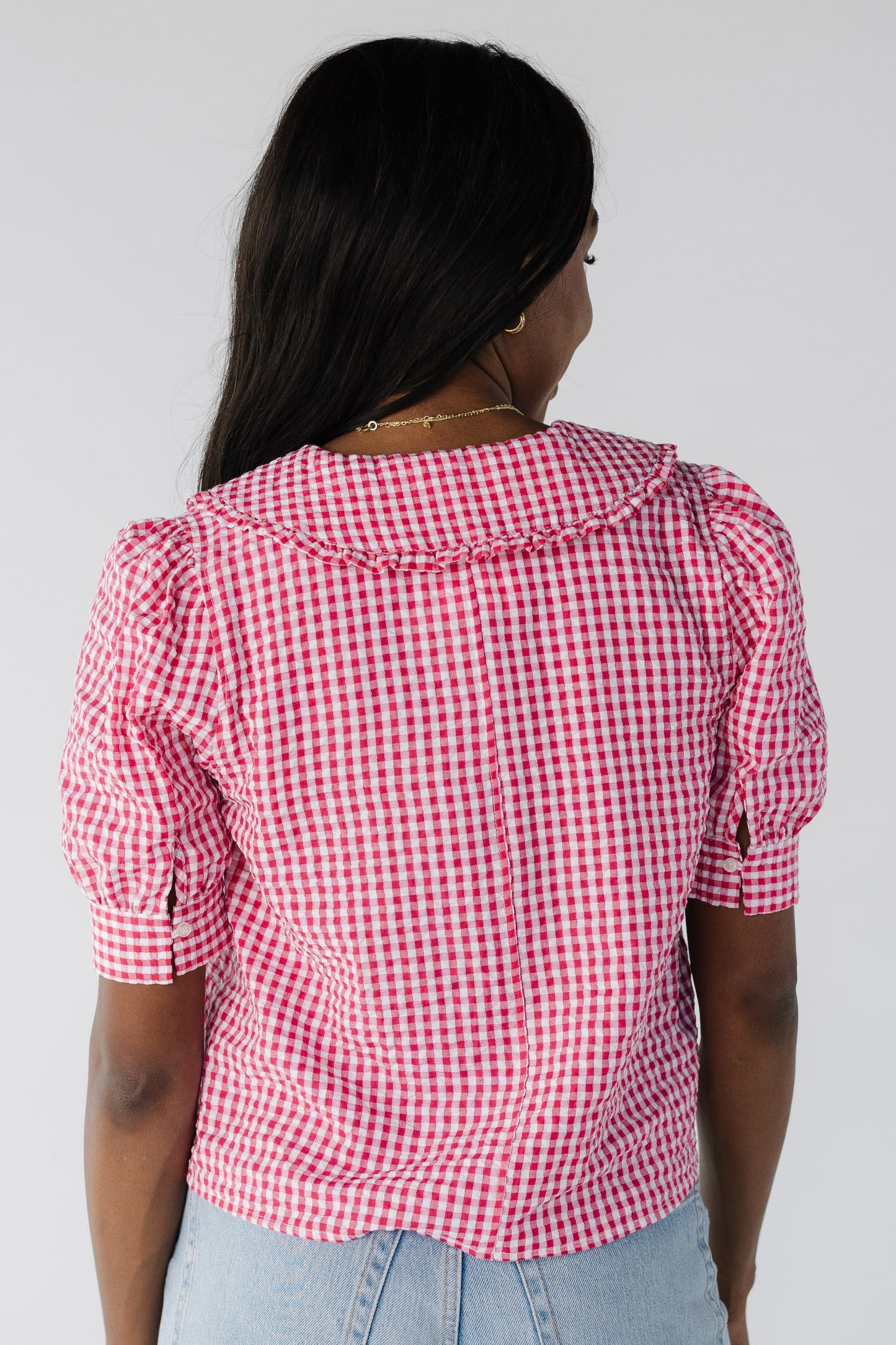Back view of red gingham with short sleeves and wide collar