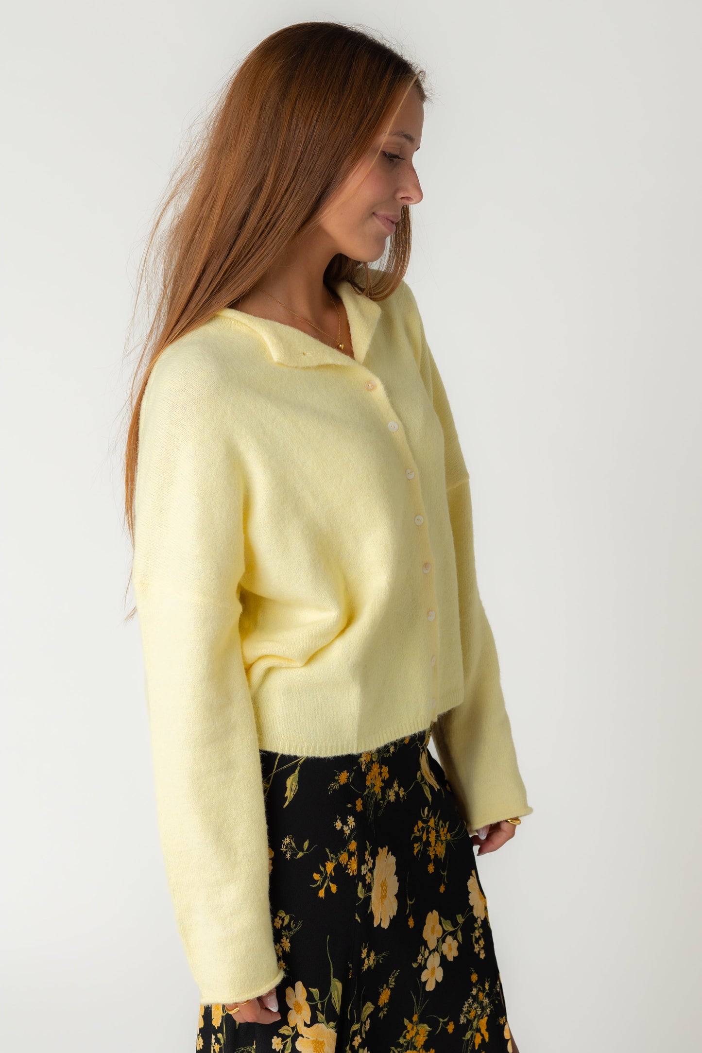 A women in a soft yellow button cardigan in light yellow
