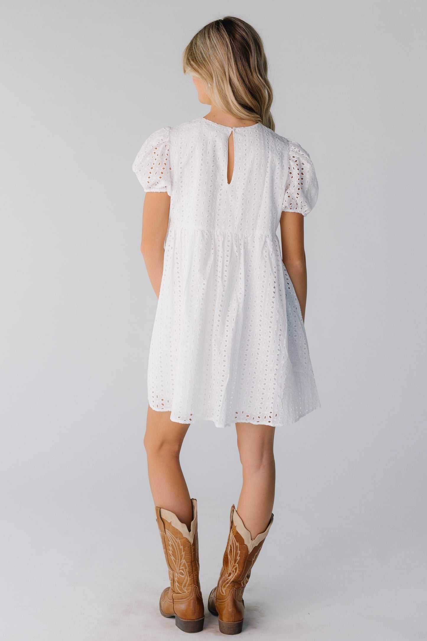 Back view of white eyelet short dress with button and keyhole closure