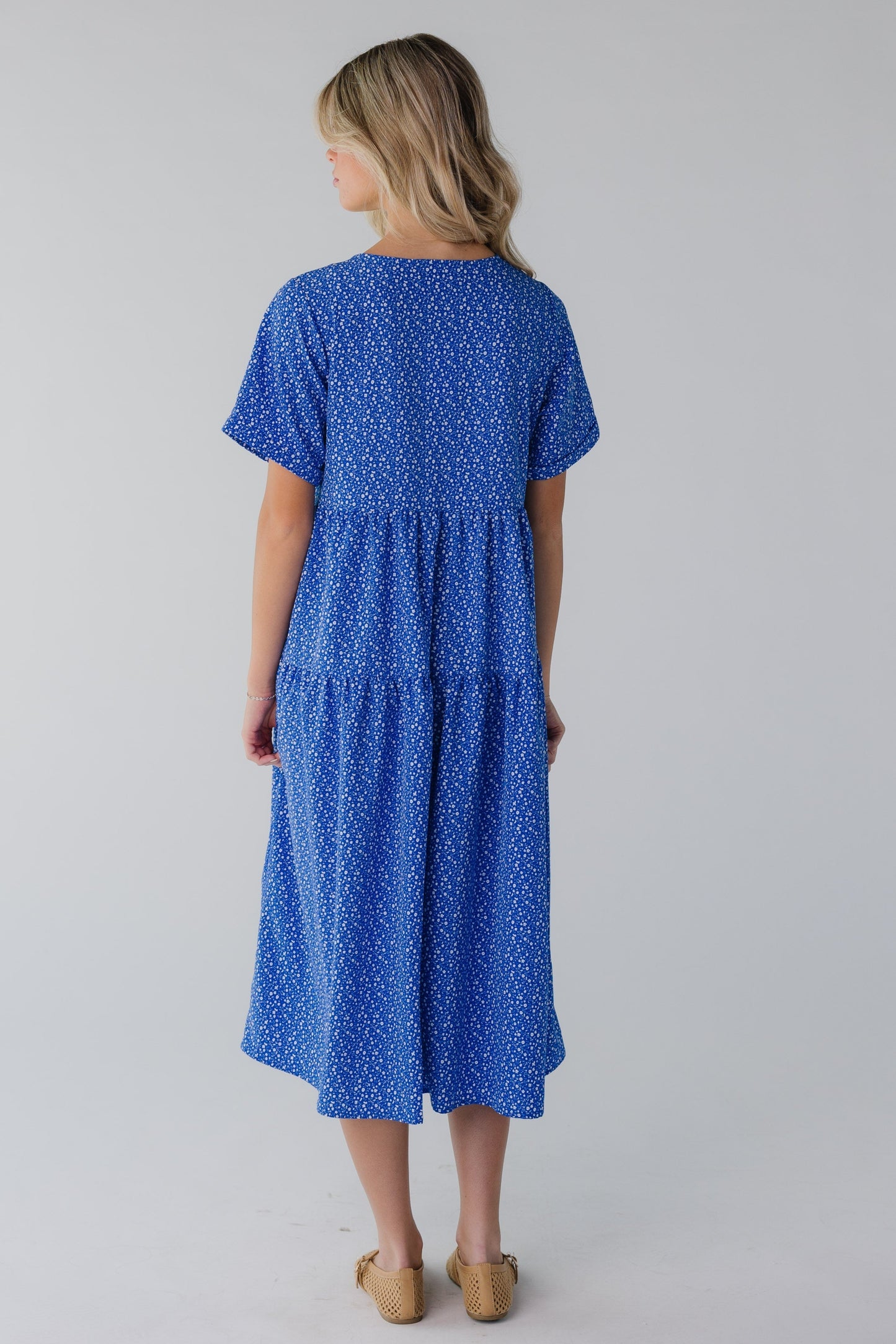 Back view of bright blue floral midi with short sleeves
