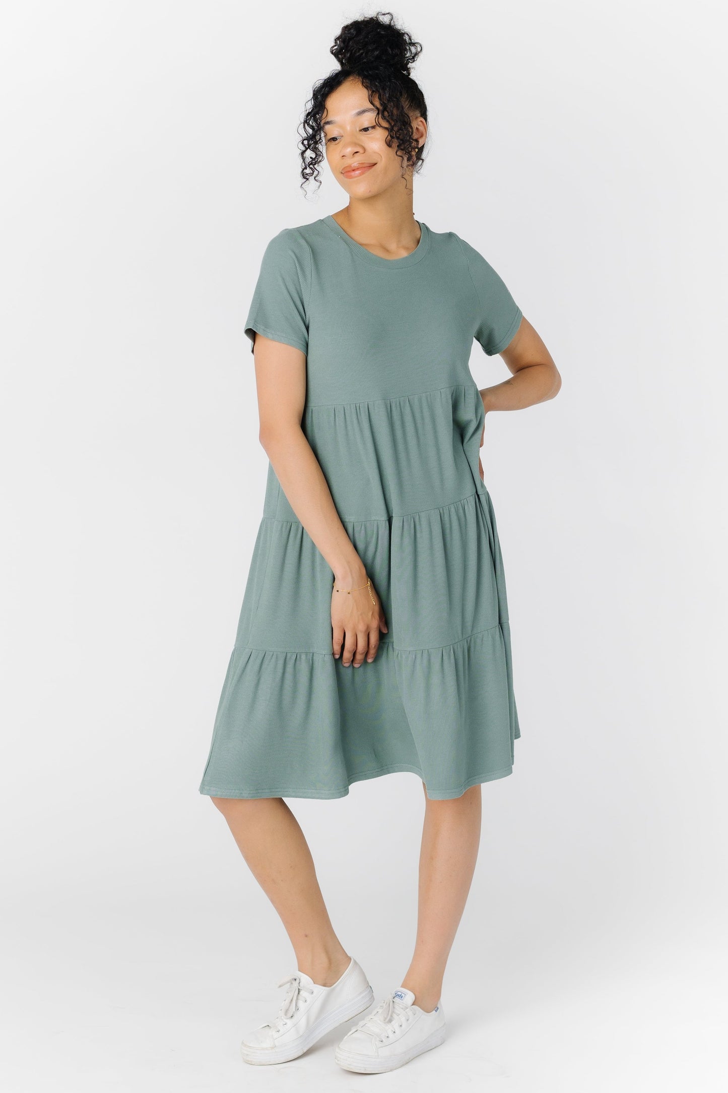 A woman wearing a knit tiered dress in seafoam green
