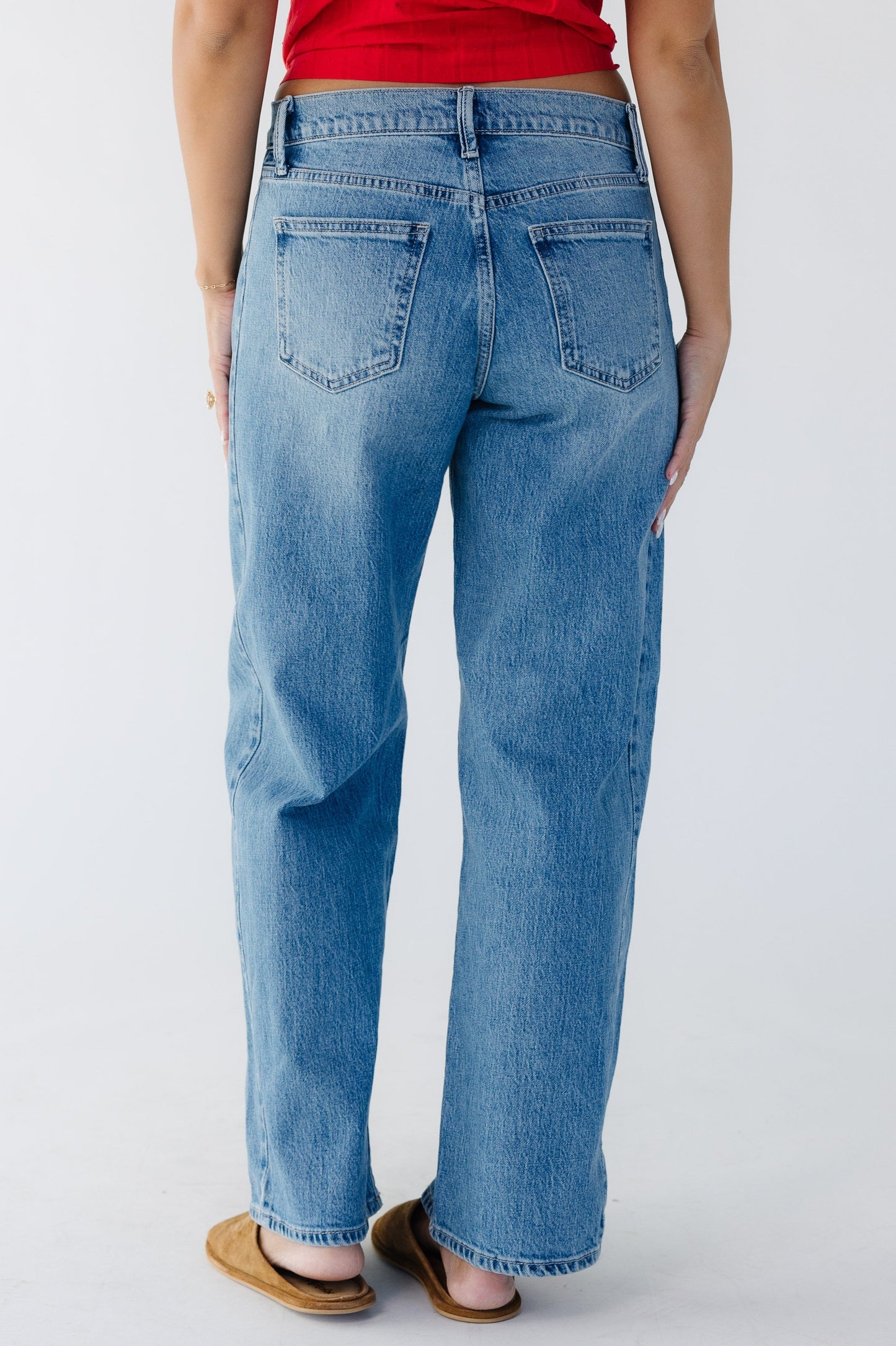 Back view of a woman wearing wide leg jeans in medium denim.