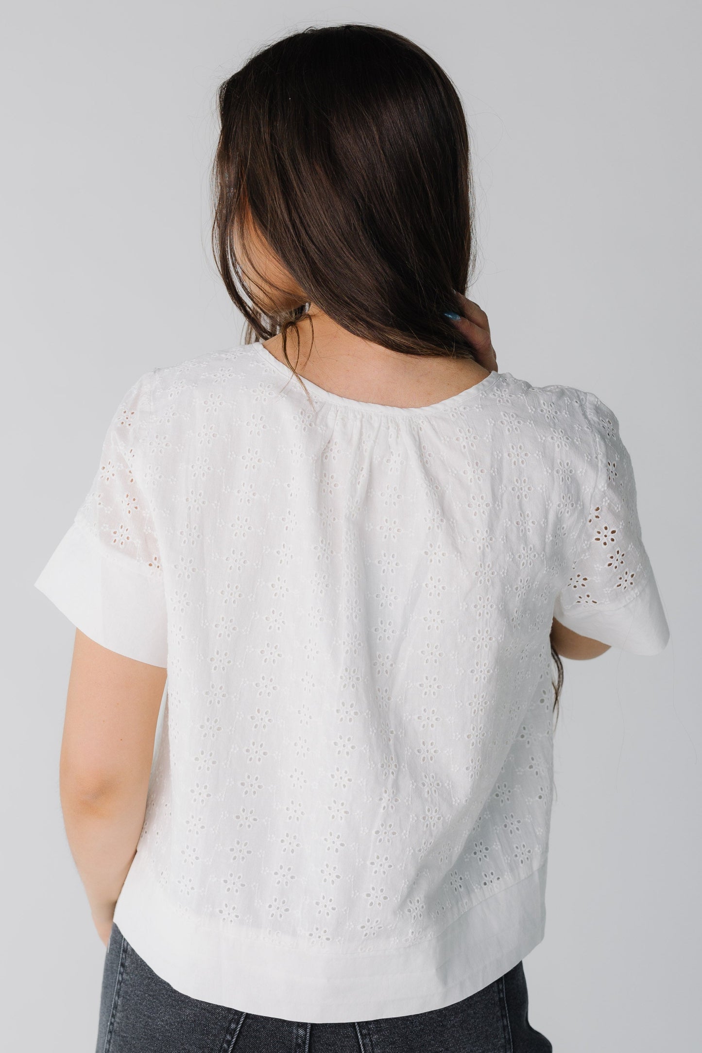 Back view of white eyelet loose fitting top with short sleeves