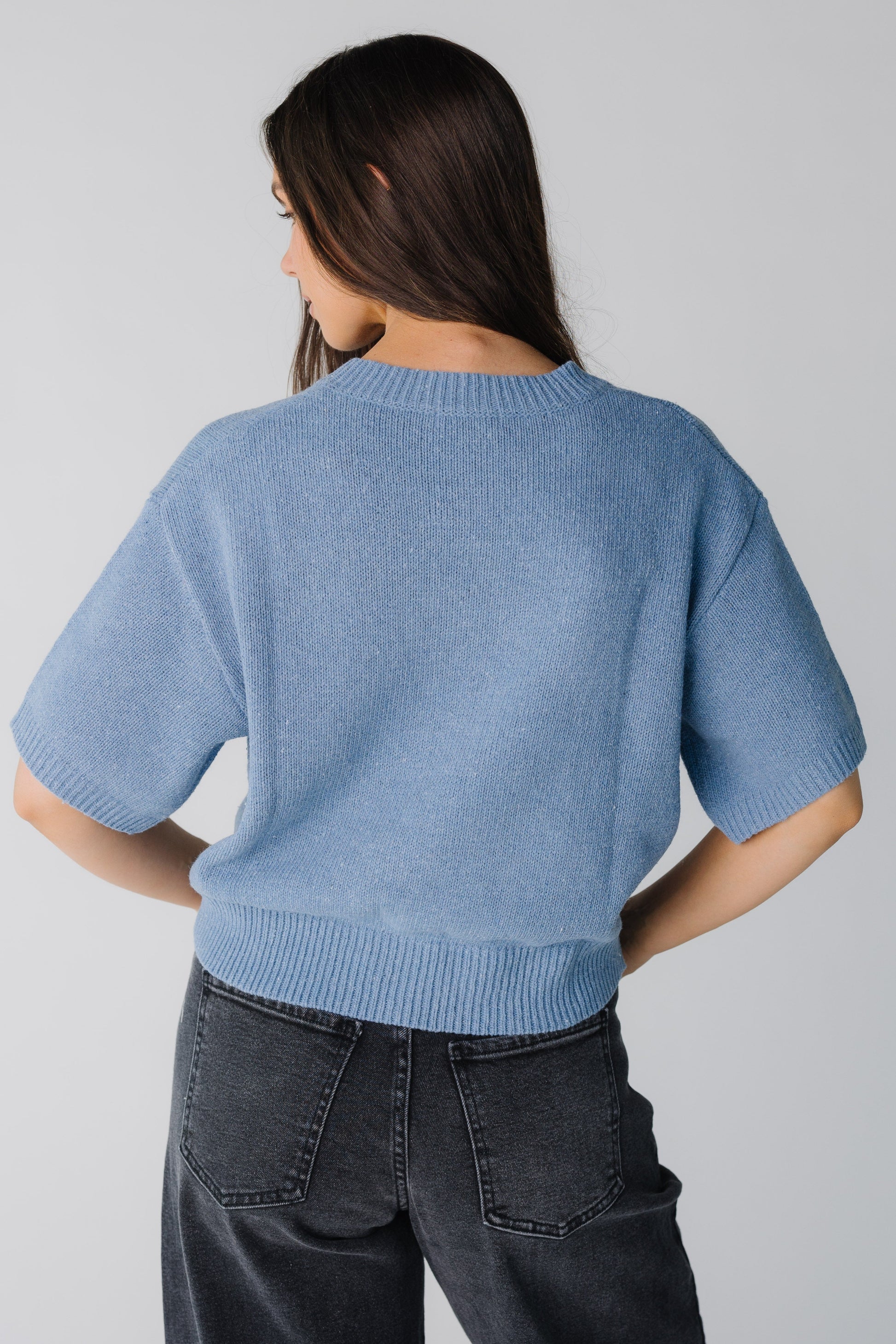 Back view of blue sweater with elbow length sleeves and wide ribbed waist