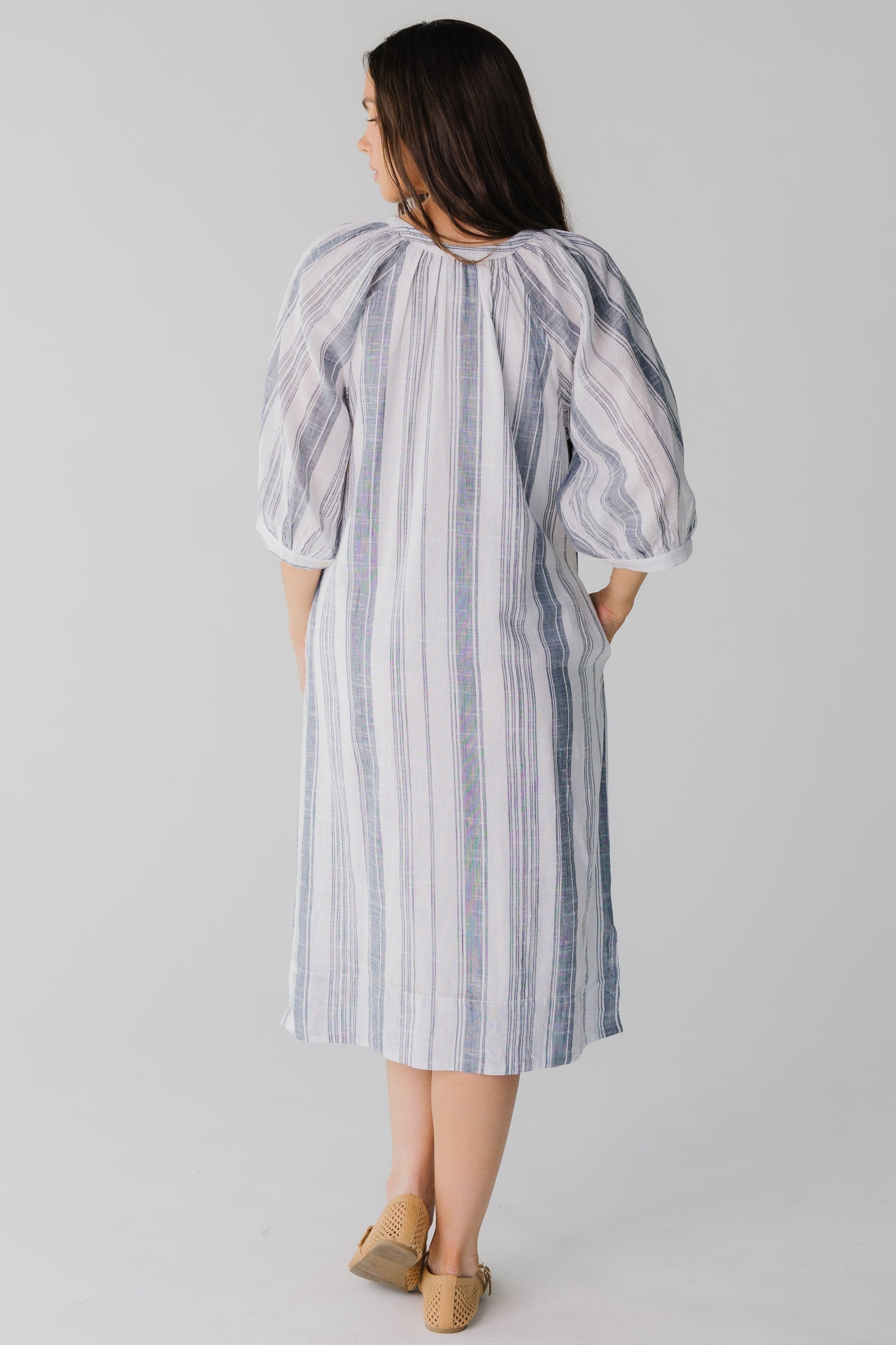 Back view of blue and white stripe midi dress with side pockets