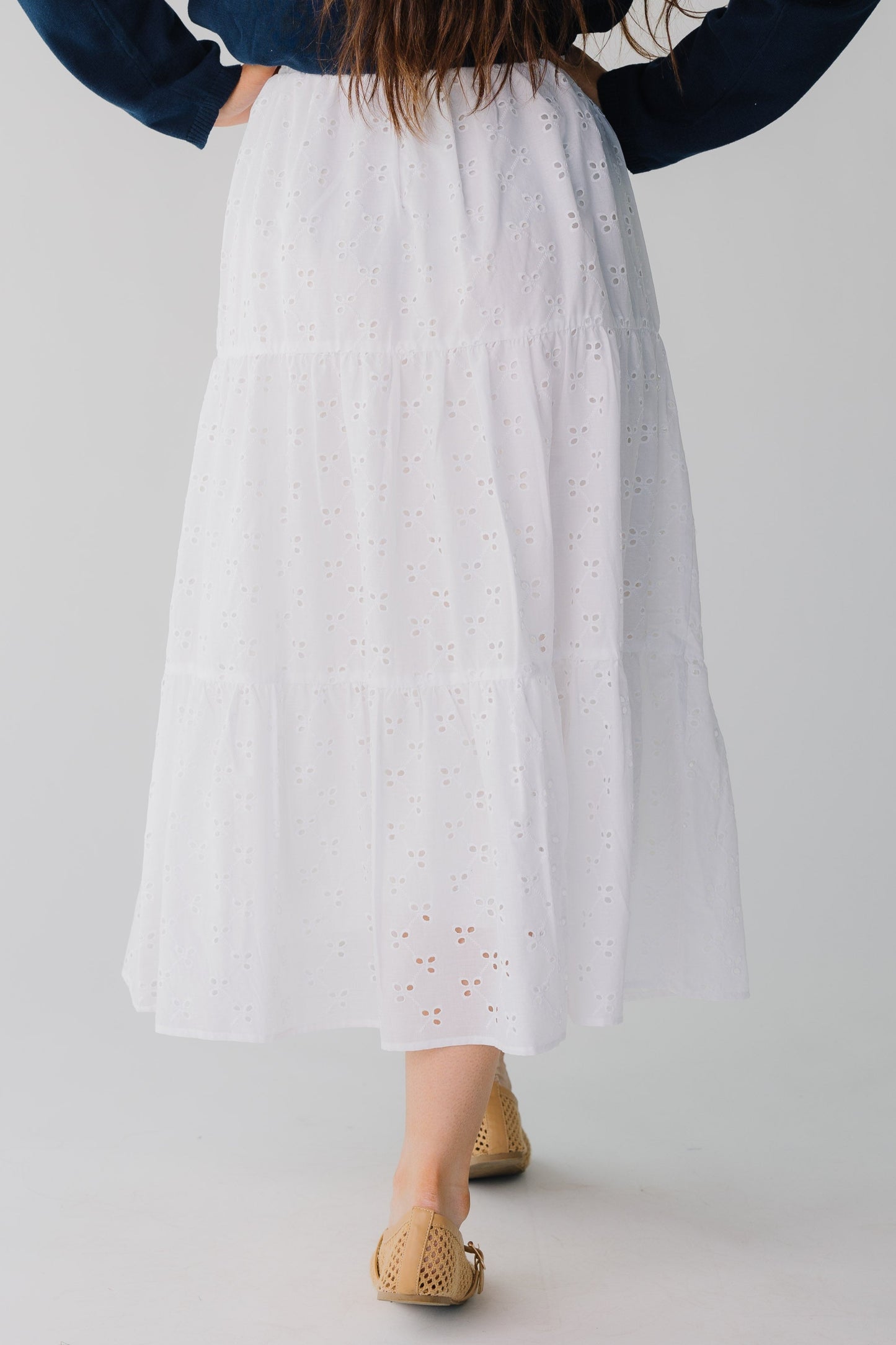Back view of white eyelet tiered midi skirt