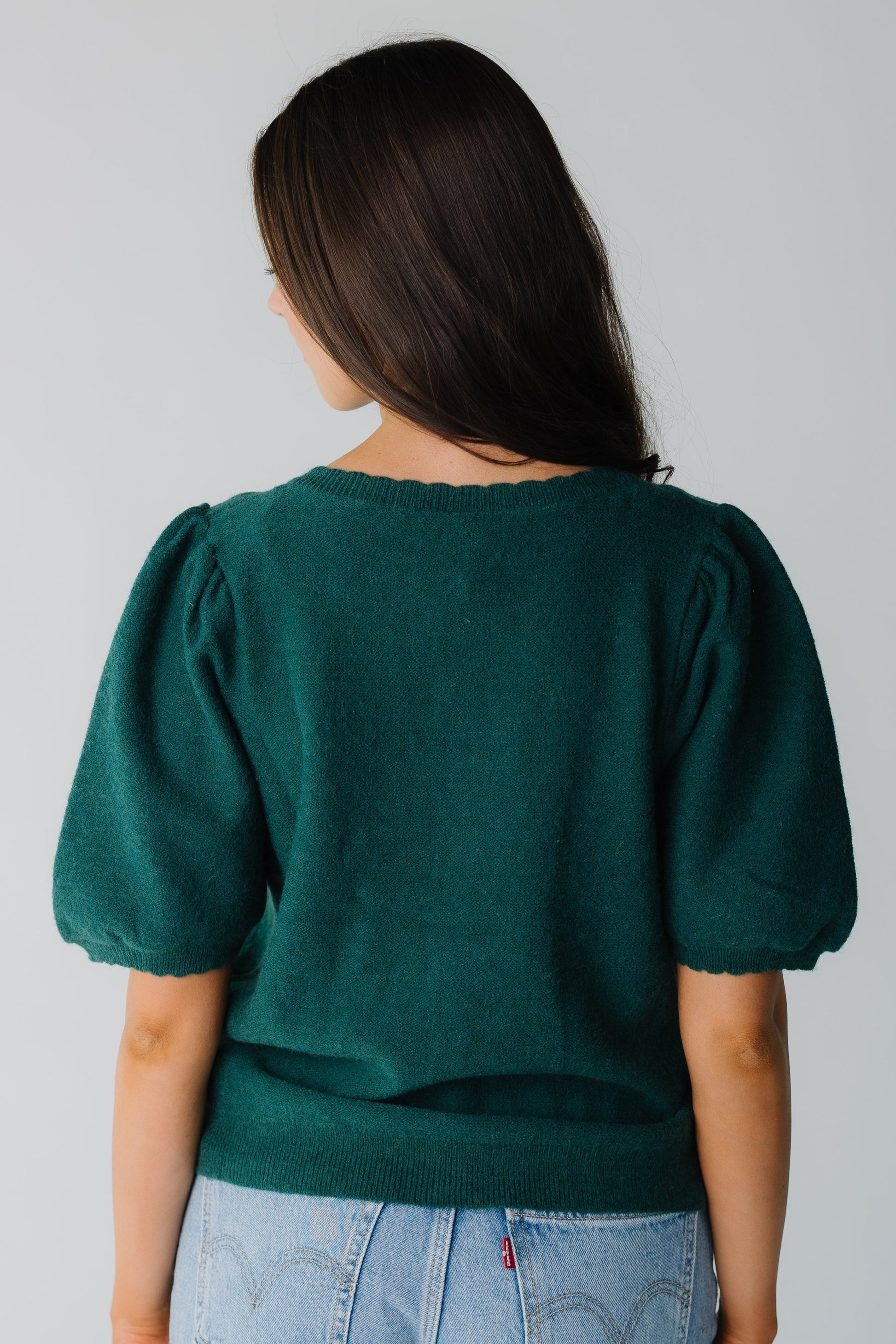 Back view of forest green cardigan with elbow length puff sleeves