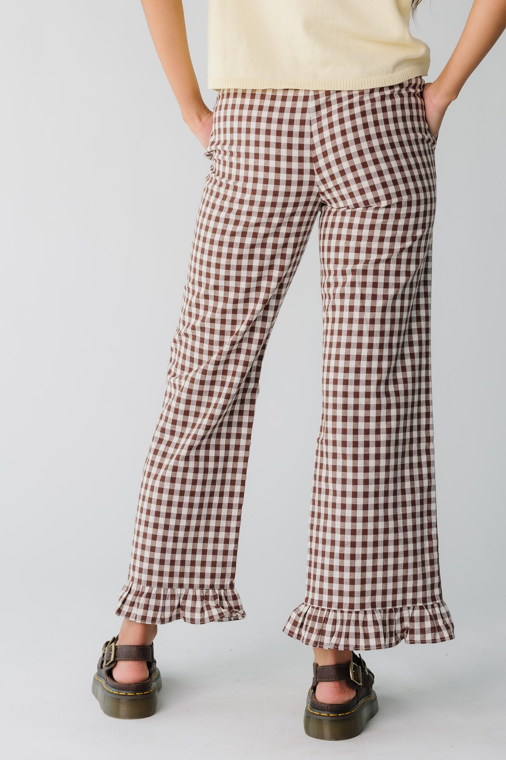 Back view of women's brown gingham pant with pockets and bottom ruffle