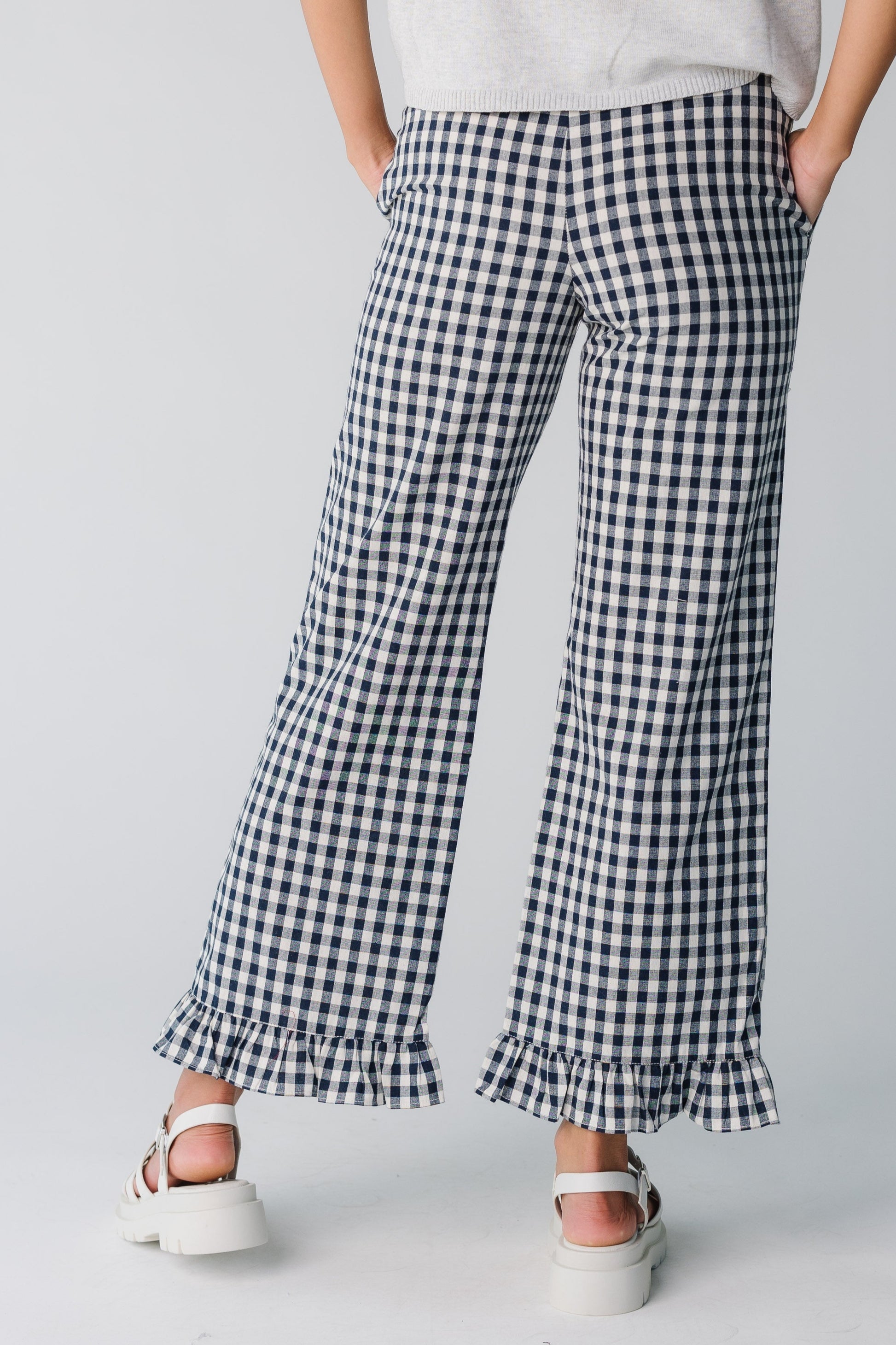 Back view of women's navy gingham wide pant with ruffle