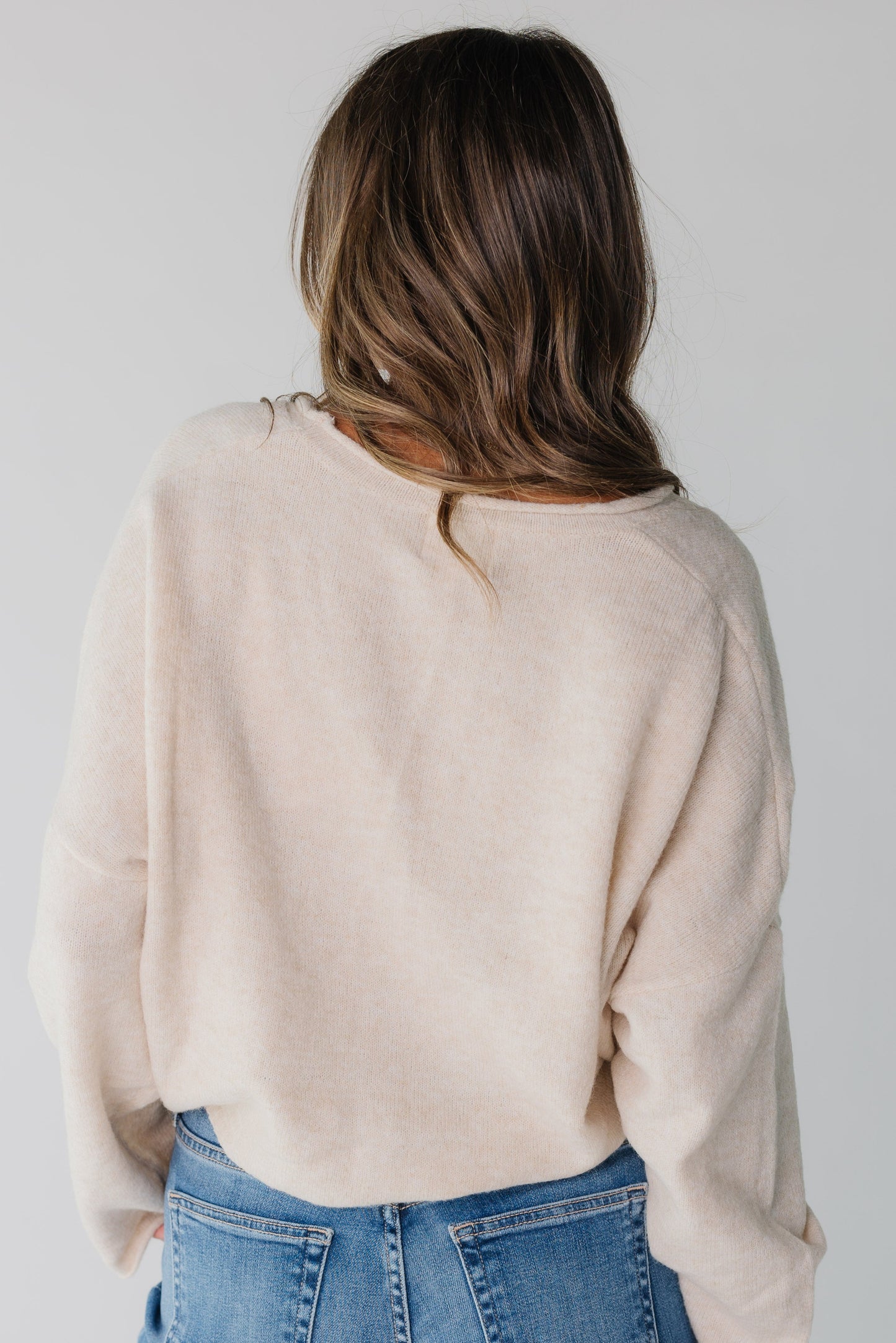 Back view of beige long sleeve sweater