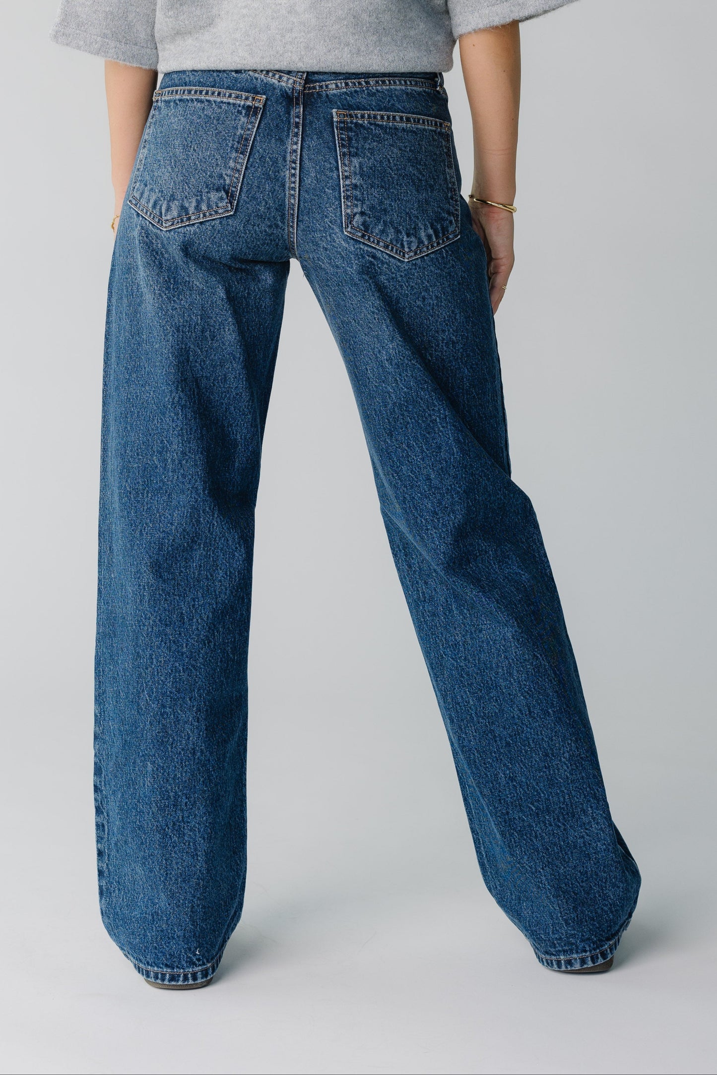 Woman wearing dark denim straight leg jeans