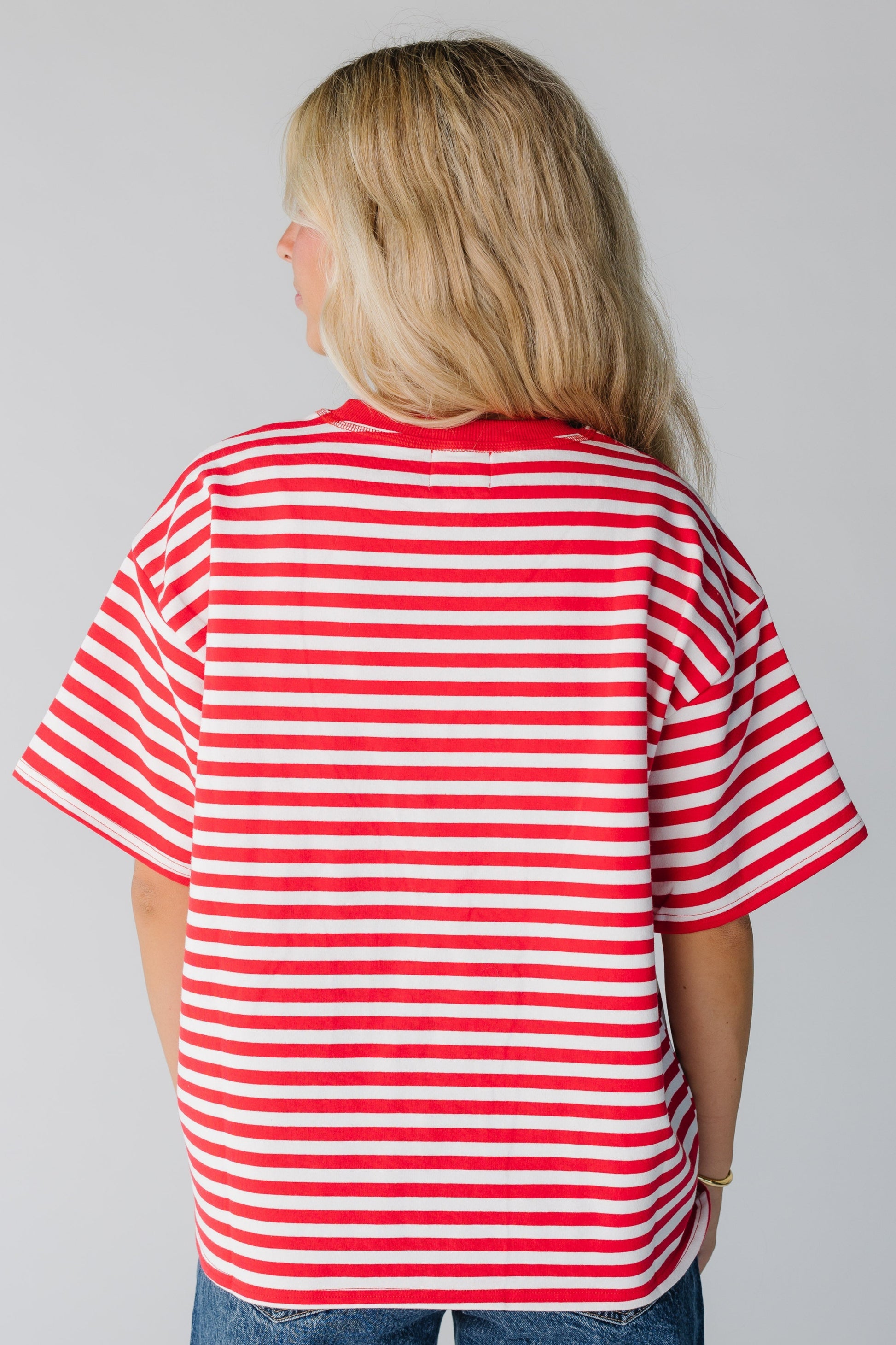 Back view of woman wearing red and white stripe loose fitting tee