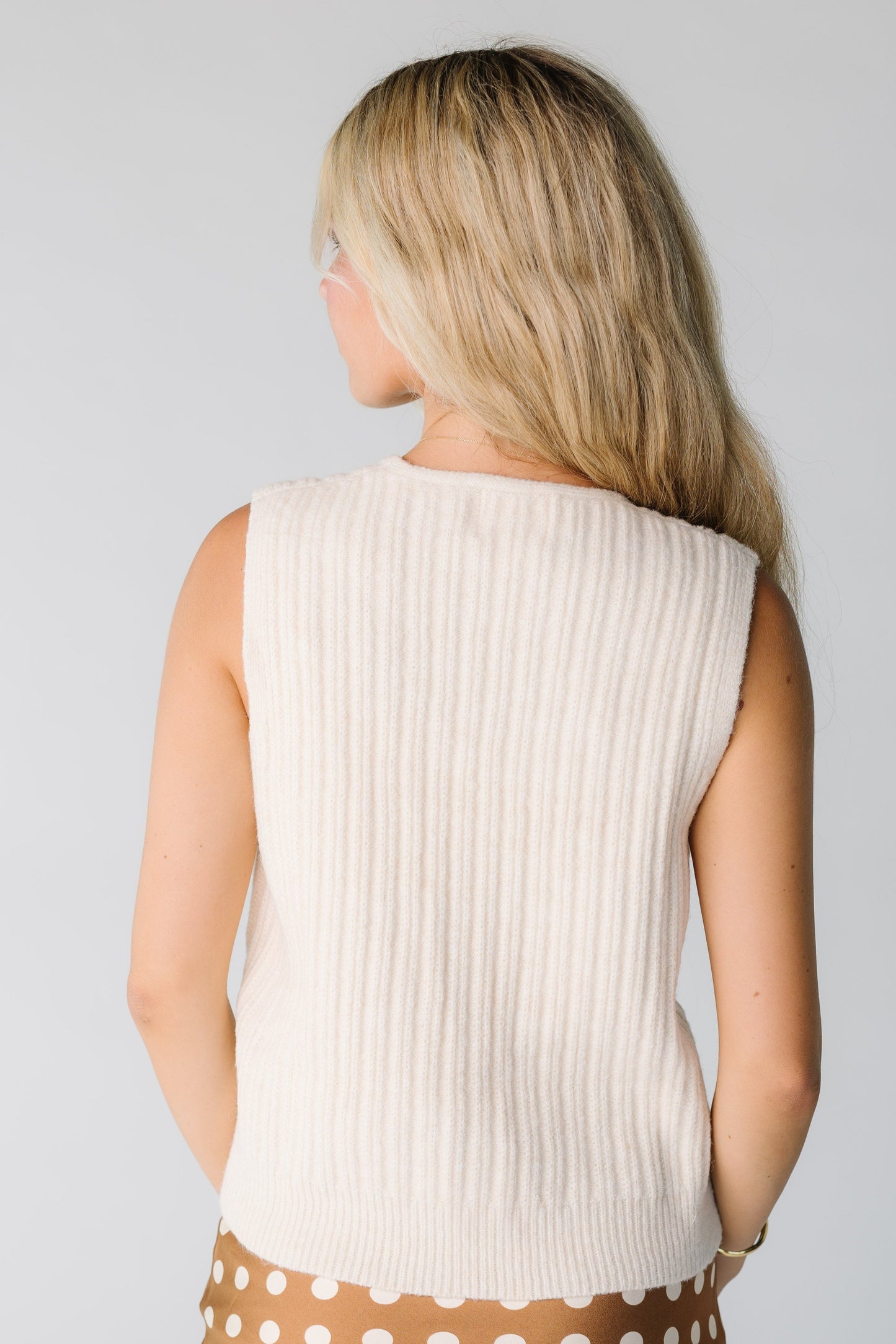 Back view of cream ribbed sweater vest