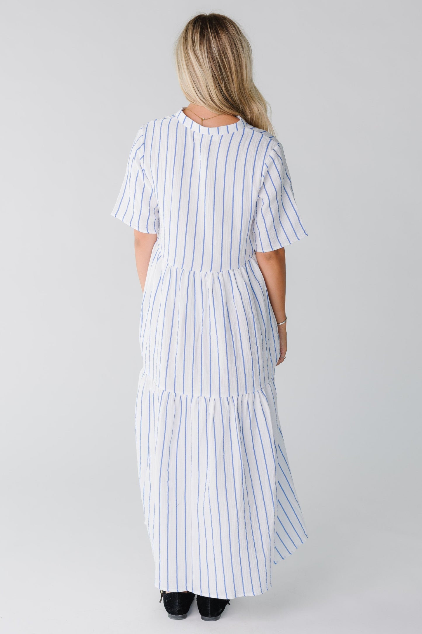 Back view of woman wearing shite and blue midi with short sleeves