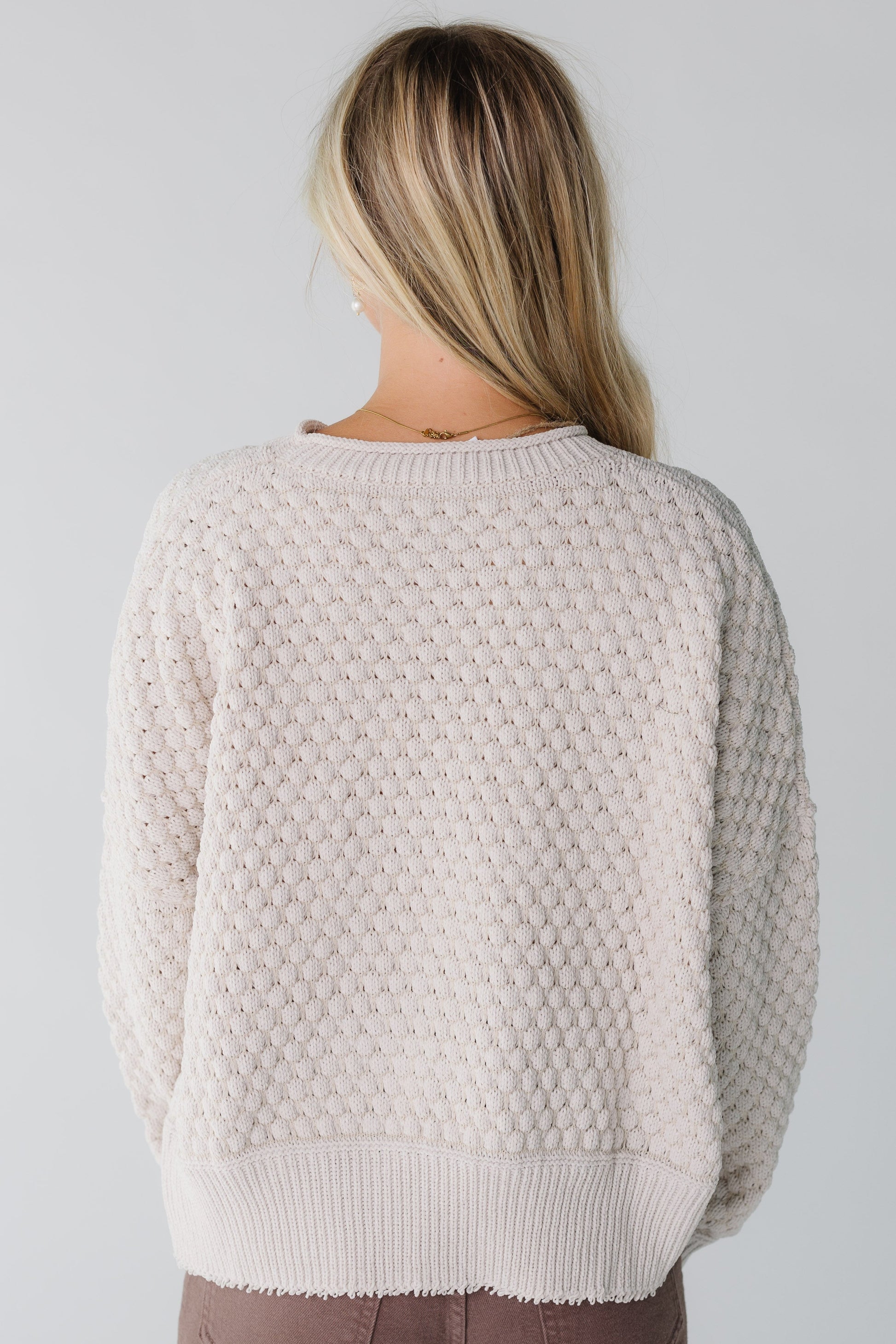 Back view of a woman in a natural textured sweater