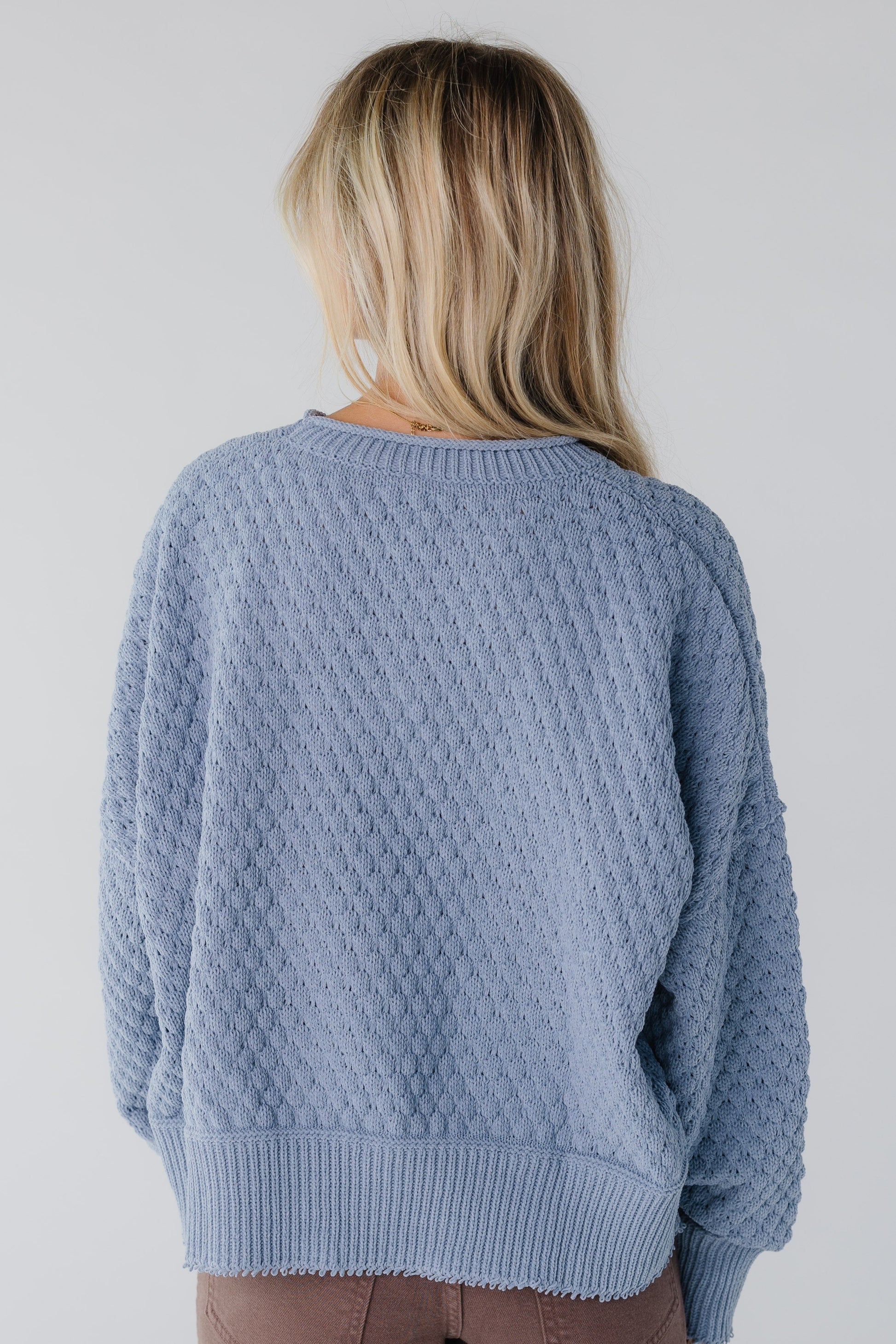 Back view of a blue textured sweater