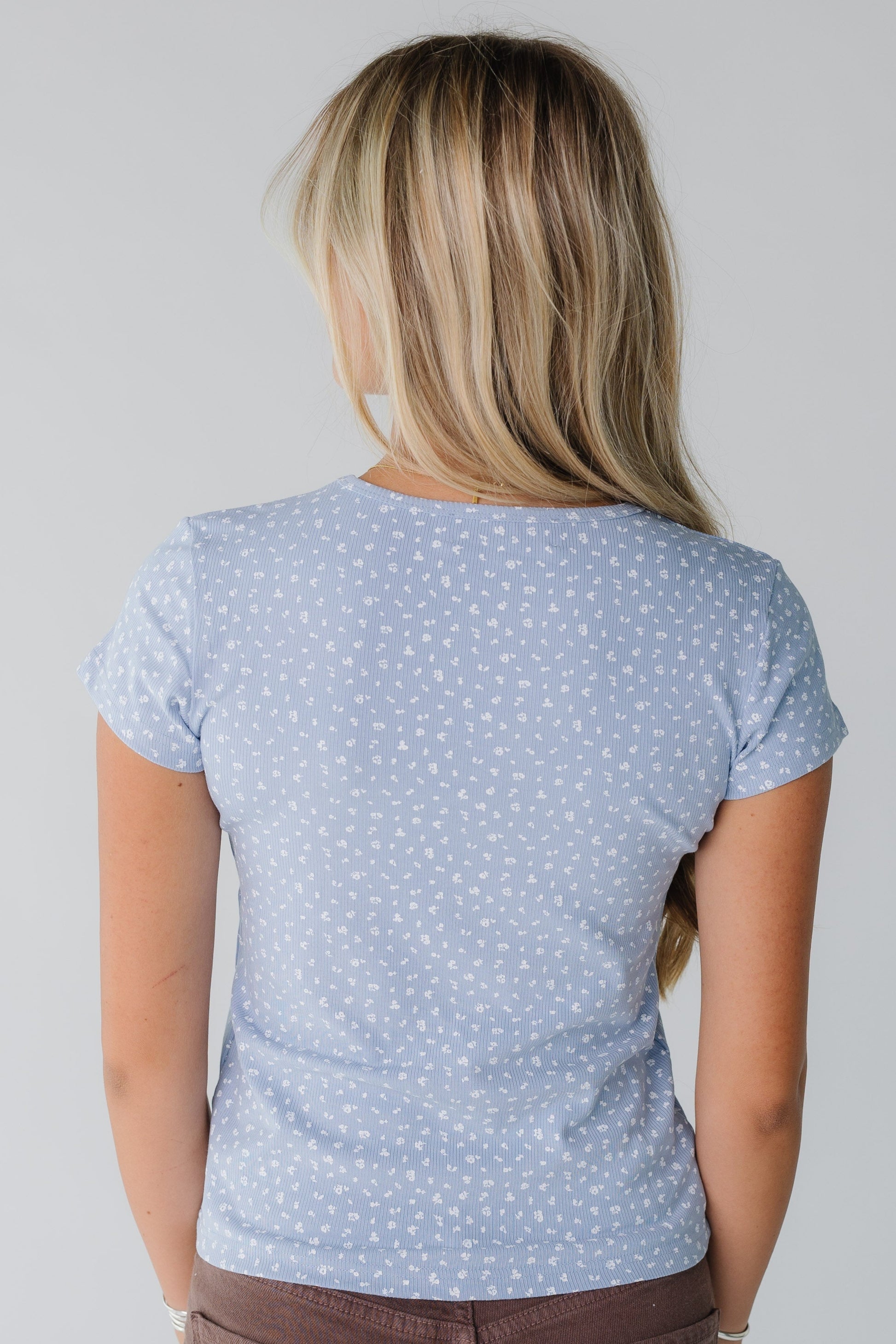 Back view of woman wearing light blue floral print top
