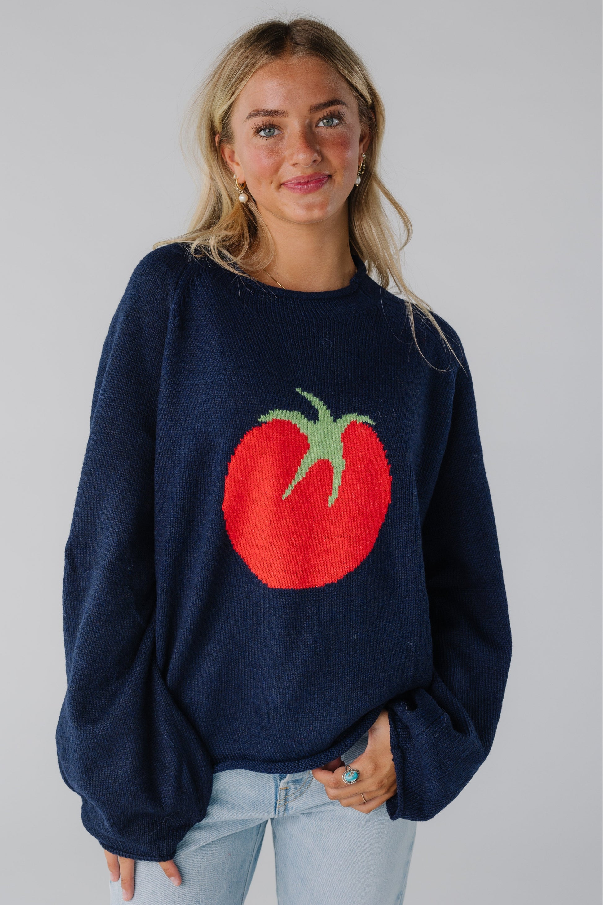 Woman wearing oversized navy graphic sweater with long sleeves and round neckline