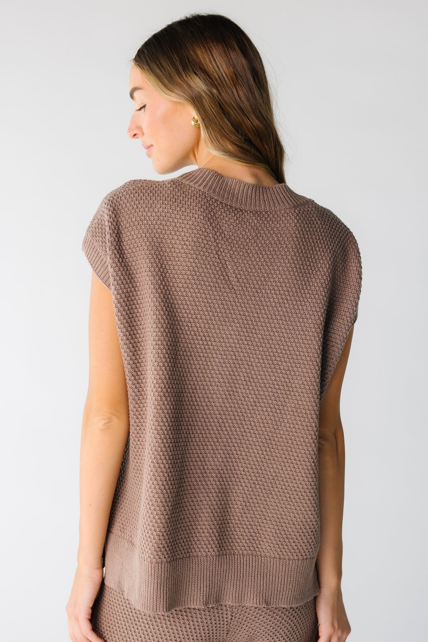 Close back view of woman wearing a sleeveless waffle textured top