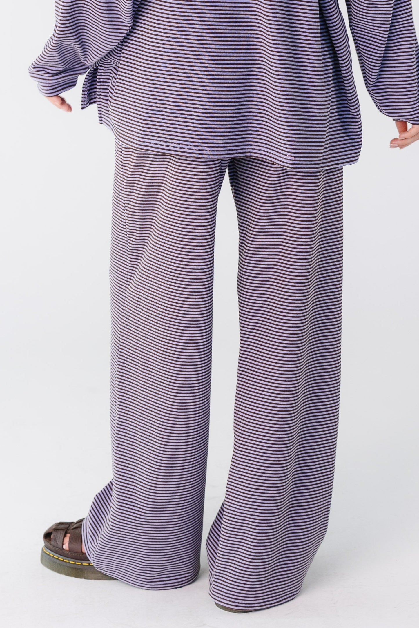 Back view of a woman wearing a wide leg stripe pant in lavender
