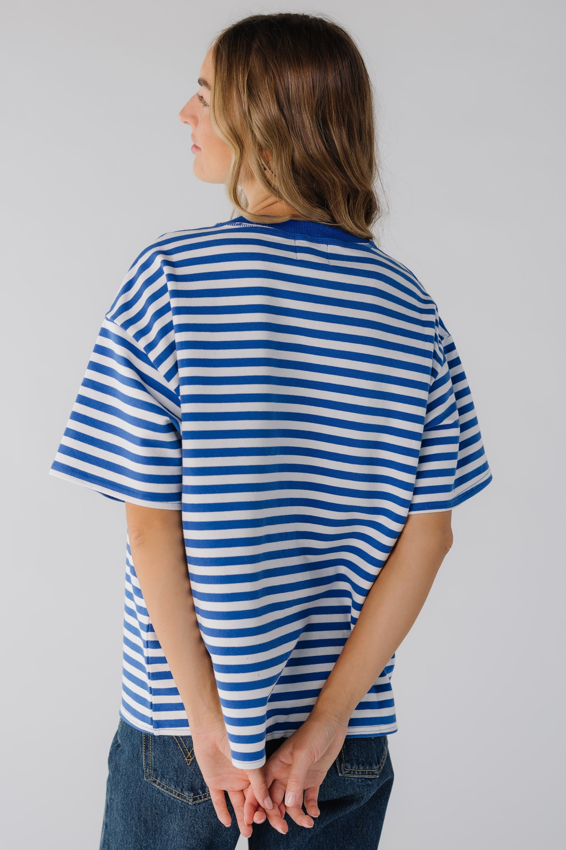 Back view of woman wearing blue and white stripe tee with short sleeves