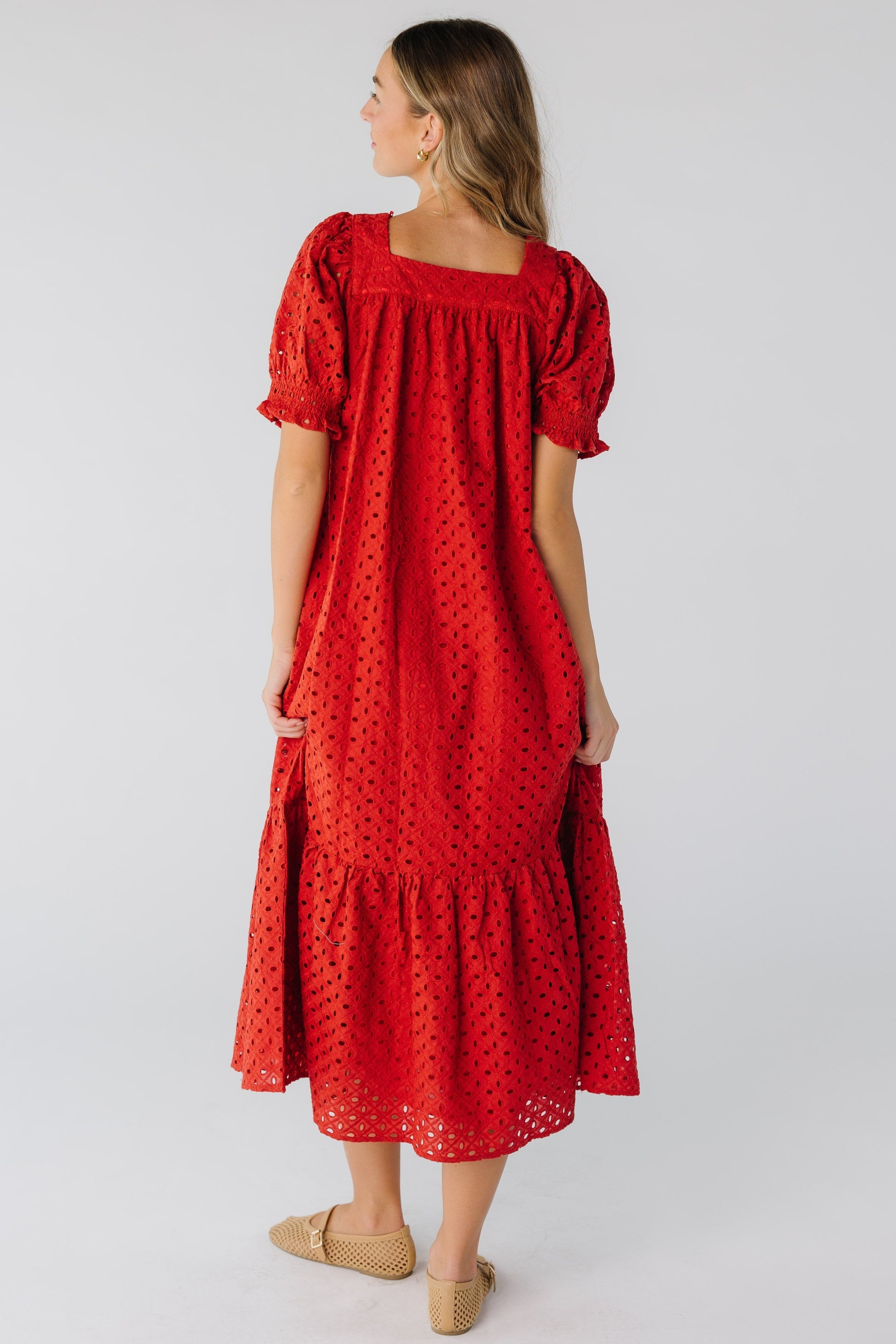 Back view of a woman in a red eyelet midi dress