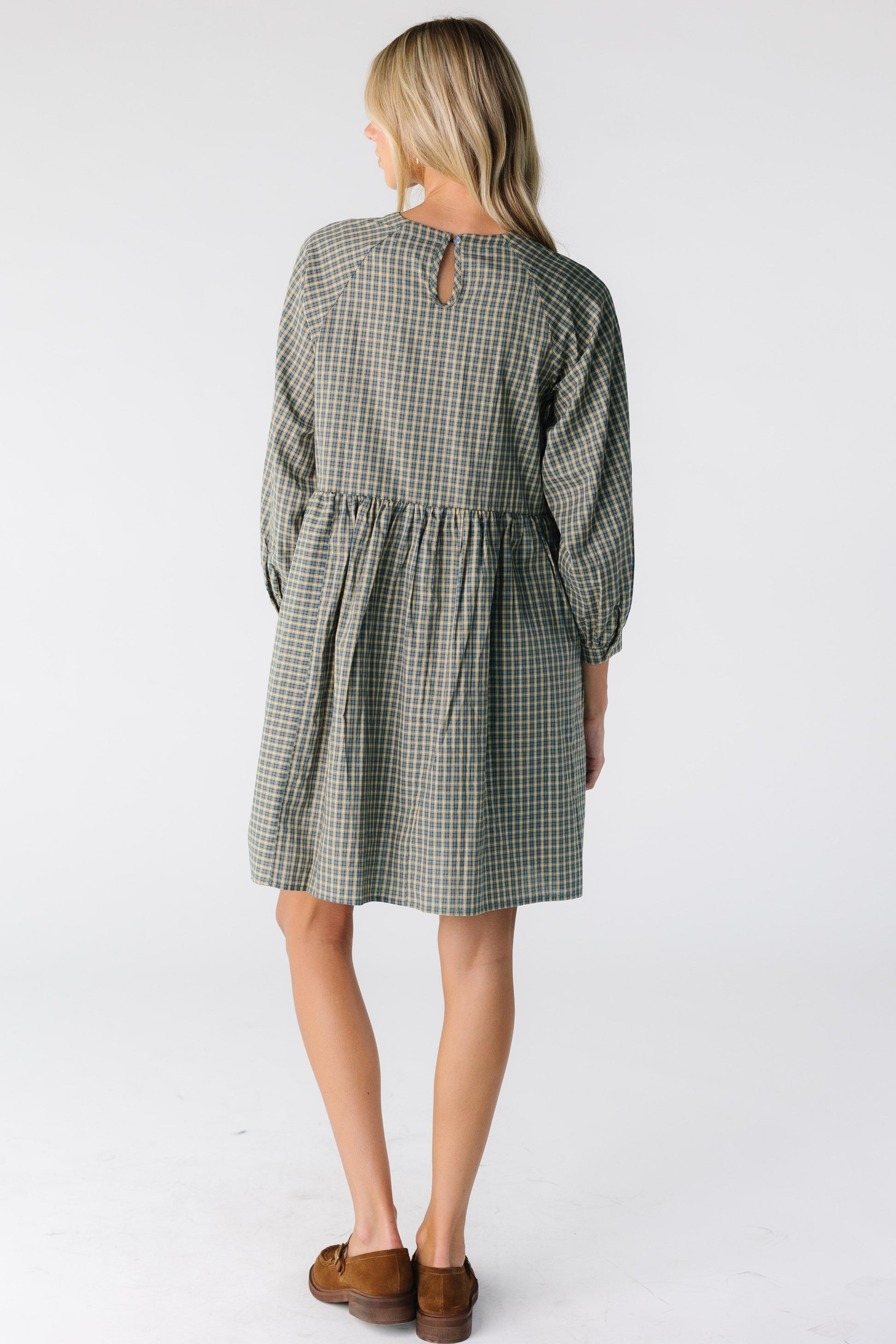 Back view of a woman wearing a green plaid dress