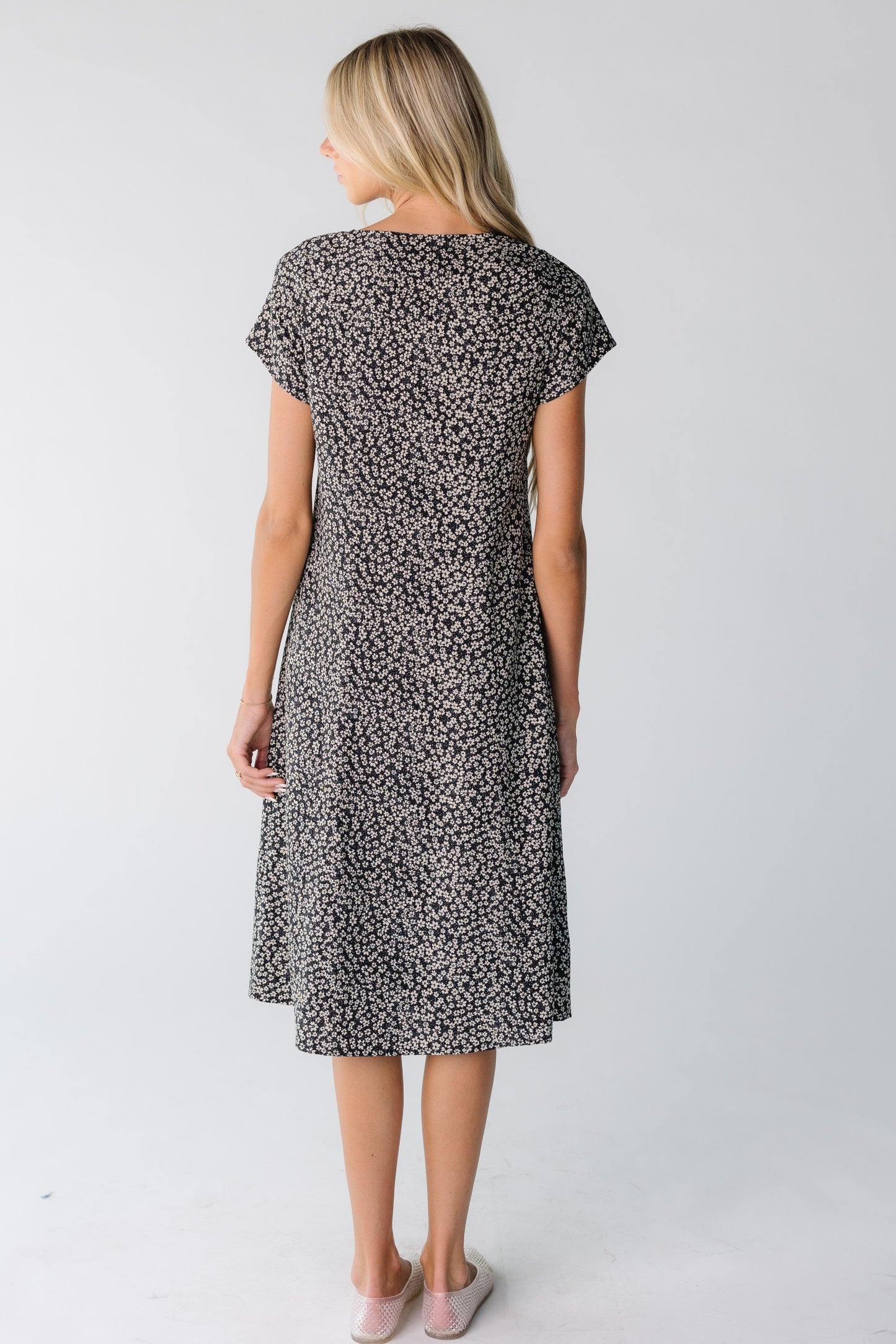 Back view of a woman wearing a black and white floral dress