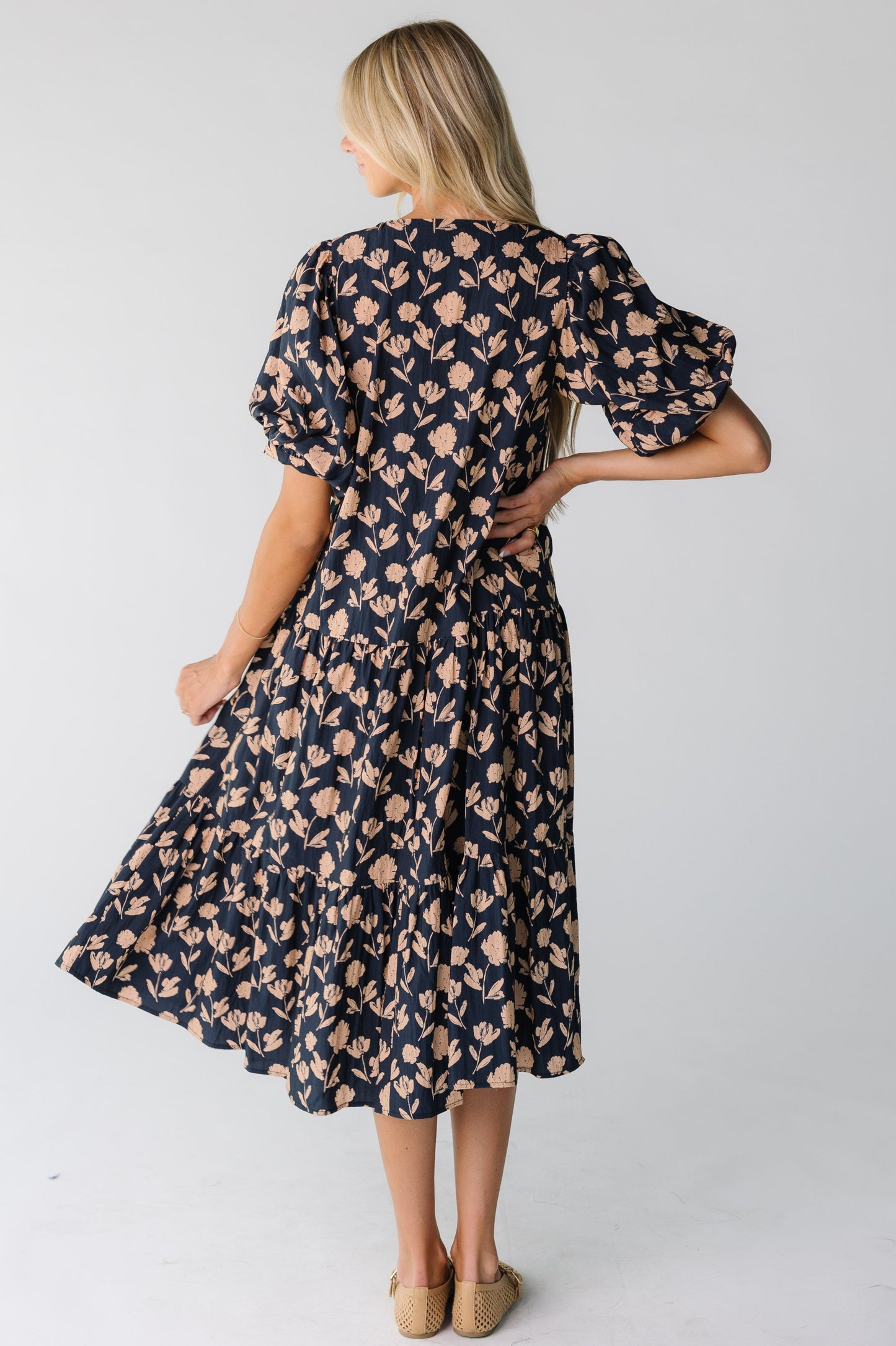Back view of a woman wearing a navy floral print dress