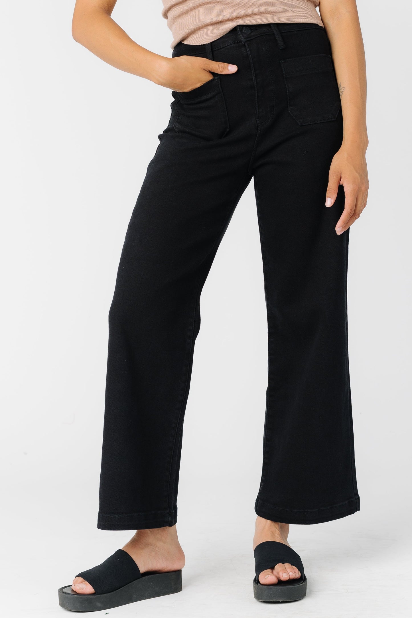 Woman wearing a pair of black wide leg jeans