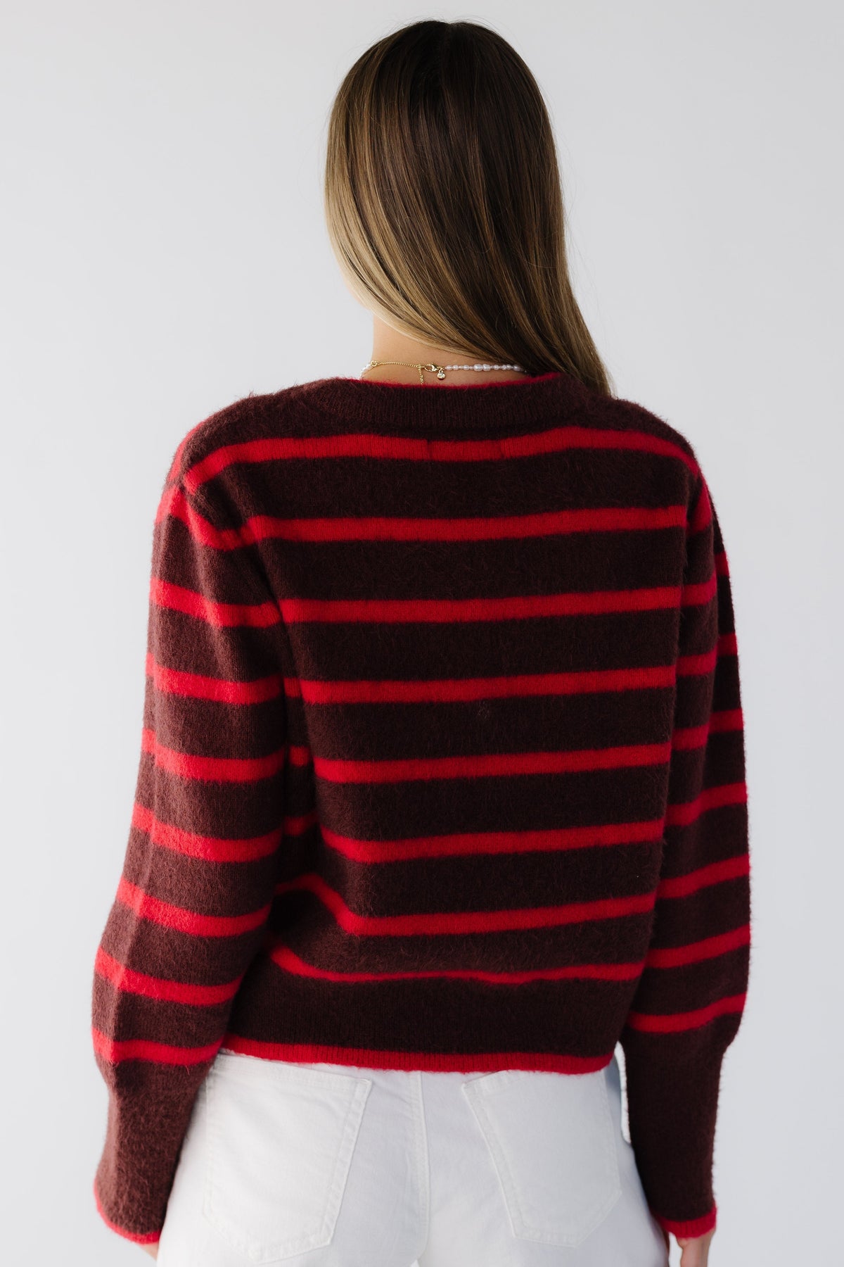 A back view of The Camilla Sweater in red & burgundy stripe sweater with extra wide ribbed cuffs.