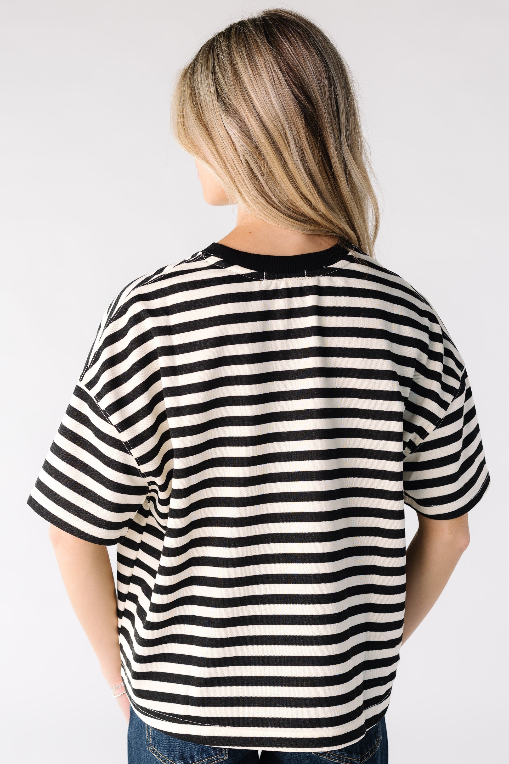 Back view of a woman wearing a black and white stripe top