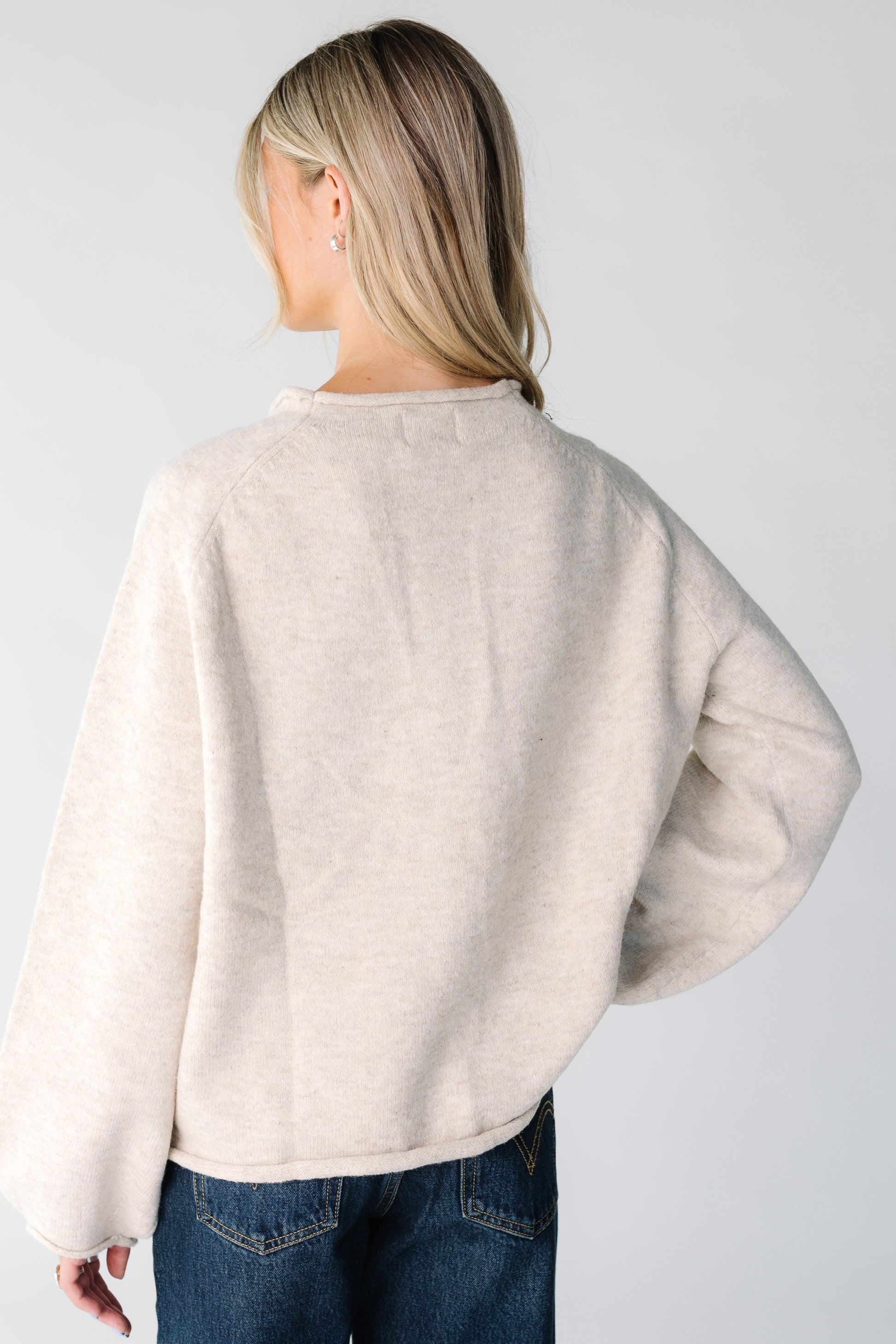 Back view of woman wearing an oat color sweater.