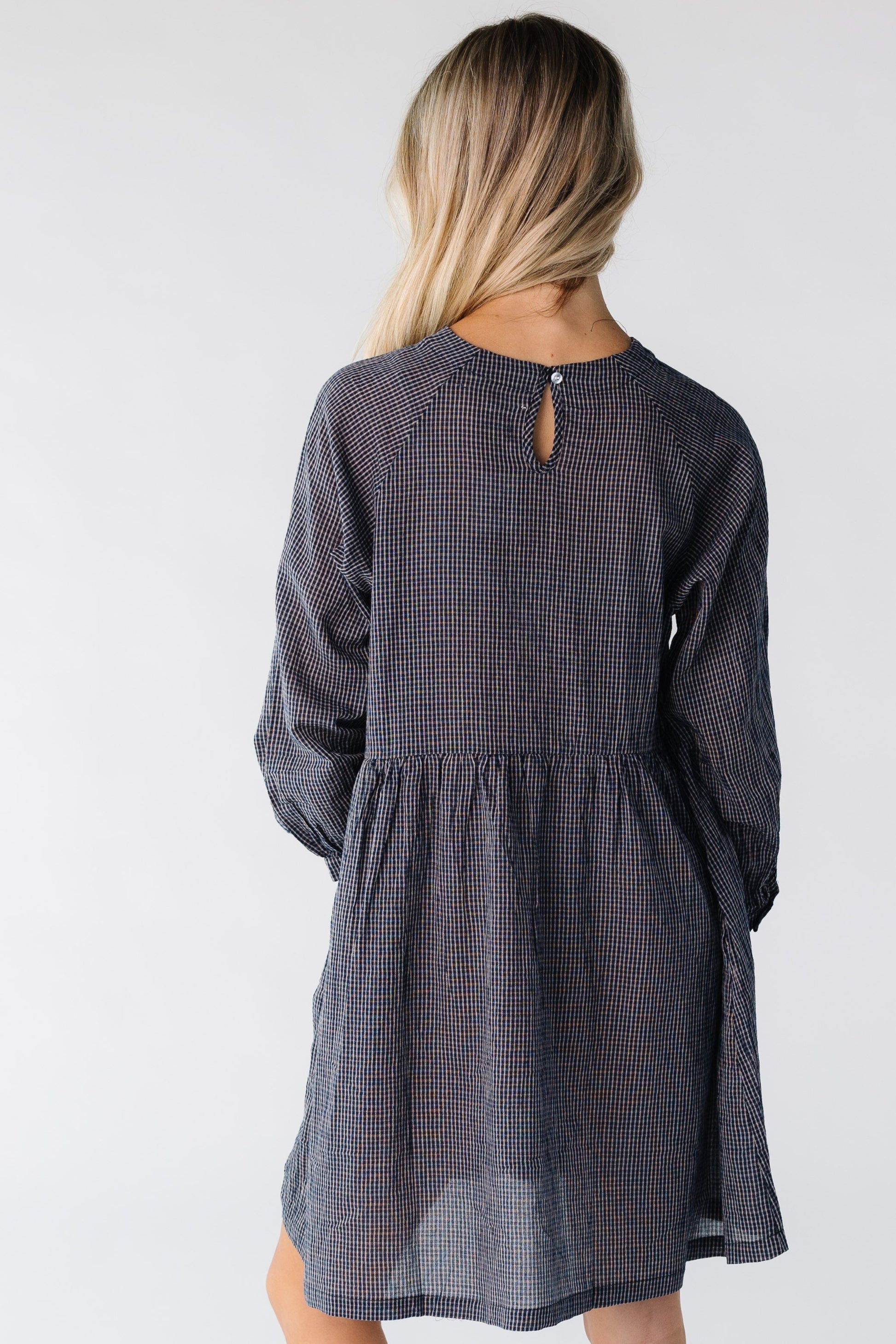 Back view of a woman wearing a navy plaid dress