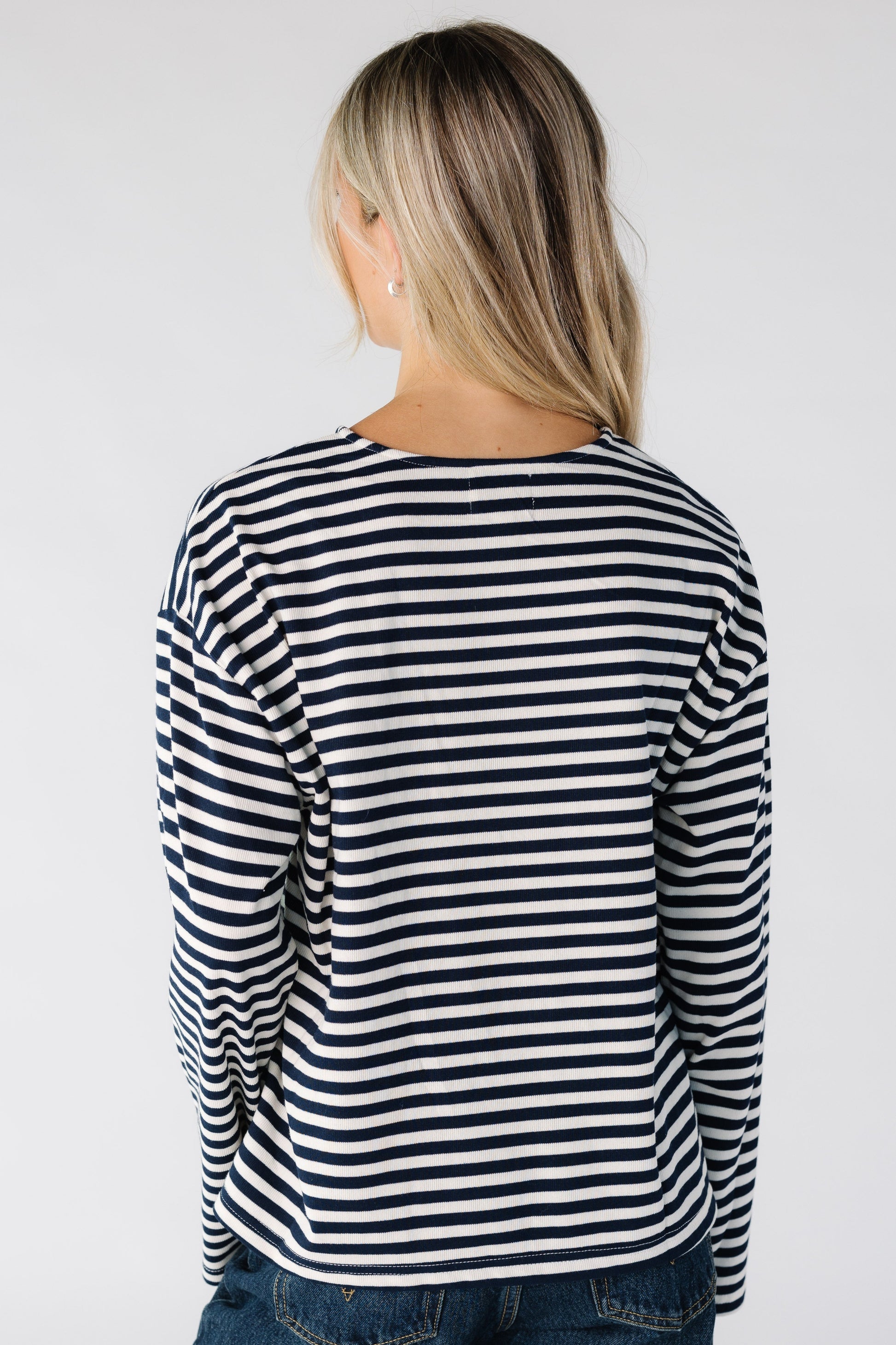 Back view of of woman wearing a black and white stripe tee with long sleeves